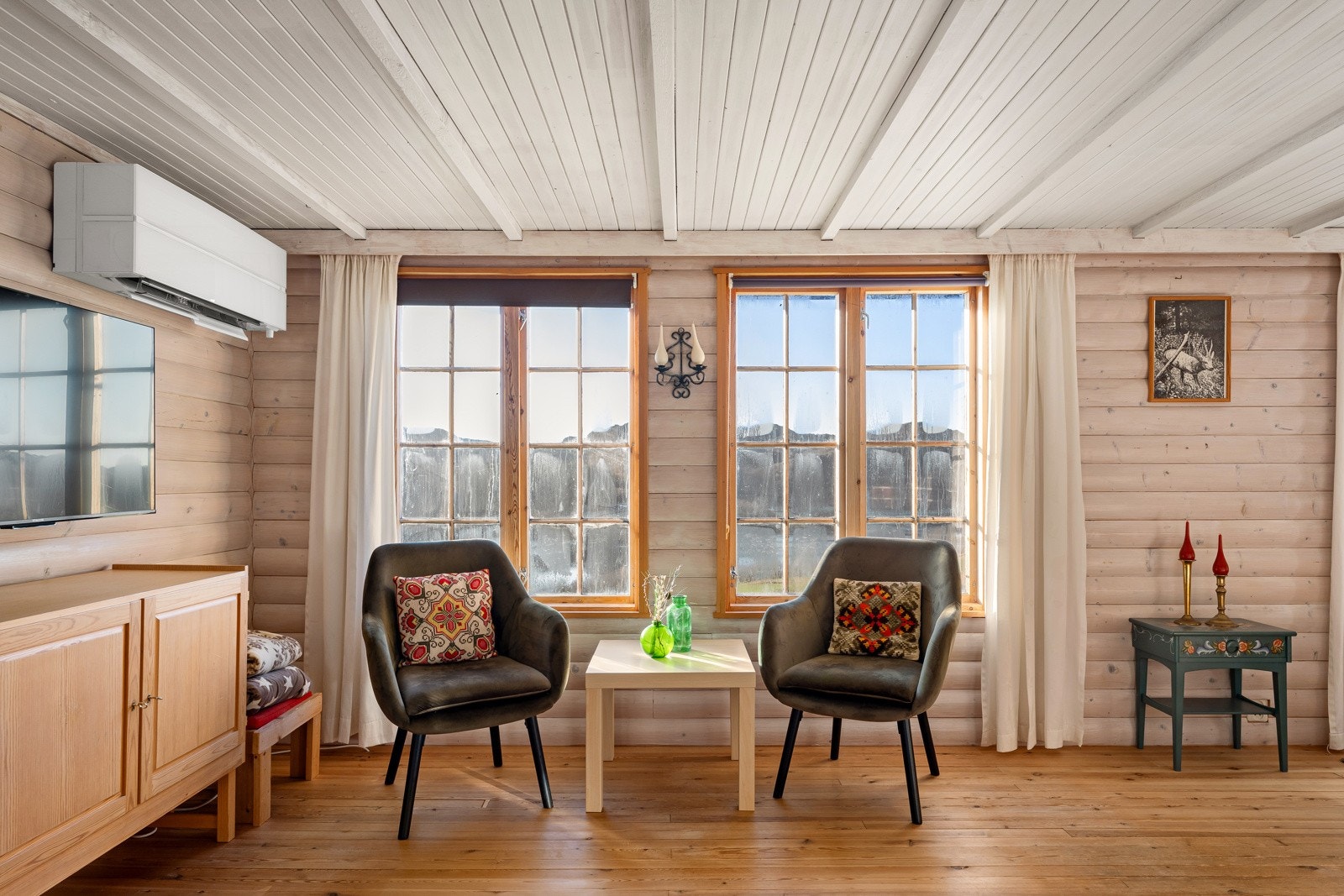 Rommet får lys fra tre retninger, og vinduene inkluderer en tofløyet glassdør fra 2021. Galleribilde