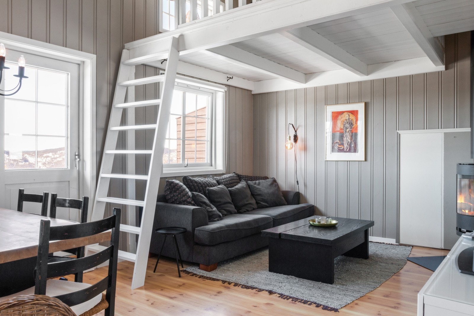 Hytta har en romslig og lys stue. Det går stigetrapp opp fra stua til hemsen. Galleribilde