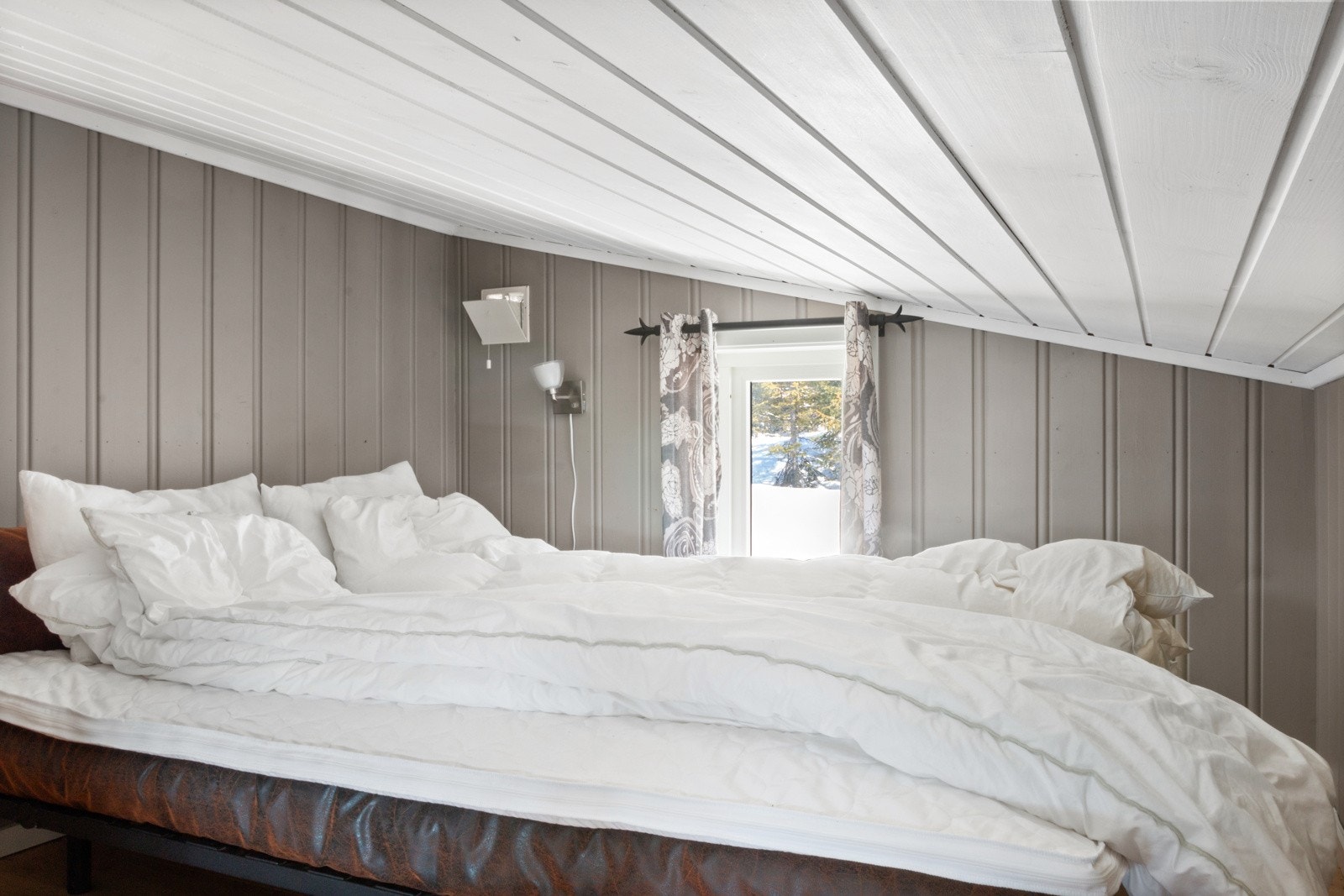 Avdelt rom med seng på hemsen. Galleribilde