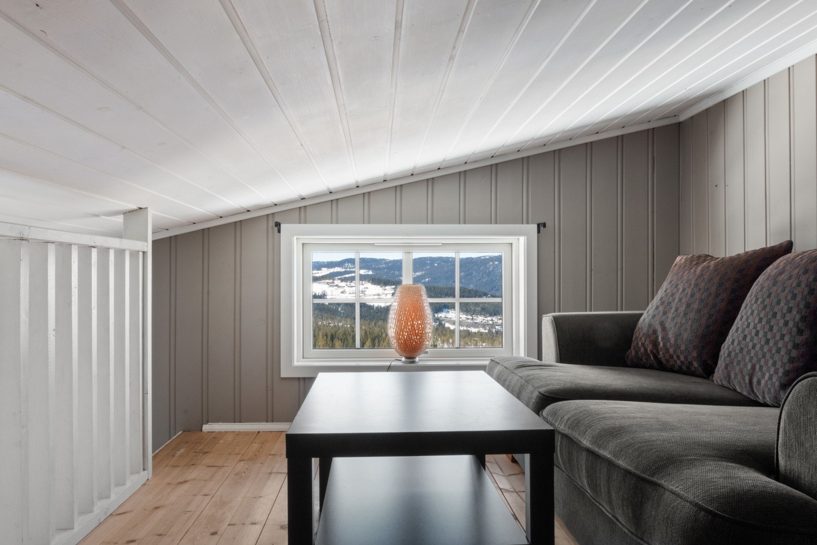 Fra hemsen er det åpent ned i stue med rekkverk og et avdelt rom med seng. Galleribilde