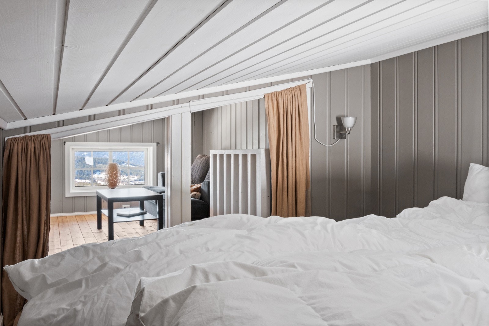 Avdelt rom med seng på hemsen. Galleribilde