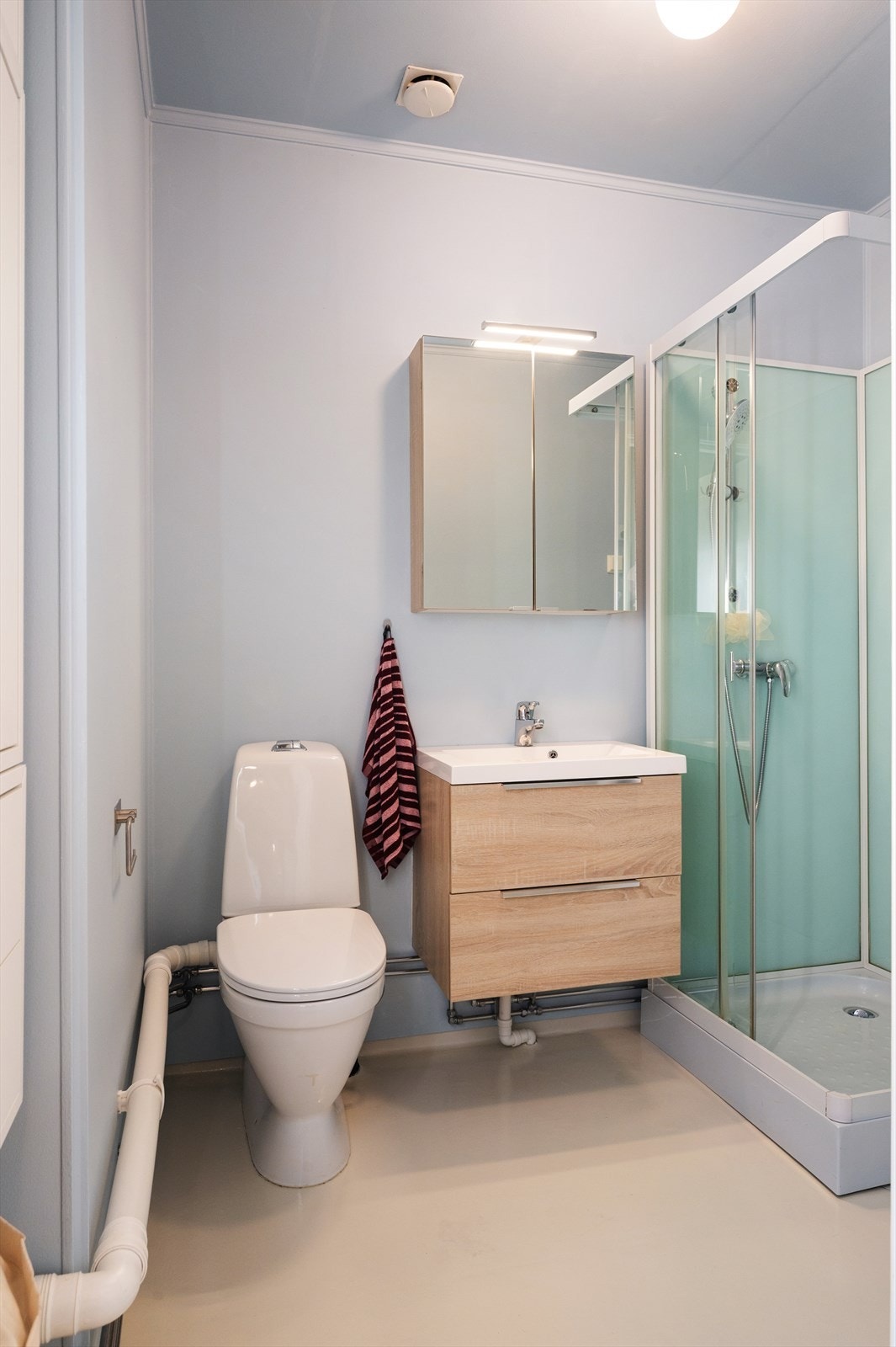 Rommet har varmekabler i gulvet, og utstyrt med dusjkabinett, toalett og en vegghengt servant med servantskap. Det er også opplegg for vaskemaskin som medfølger kjøpet. Galleribilde