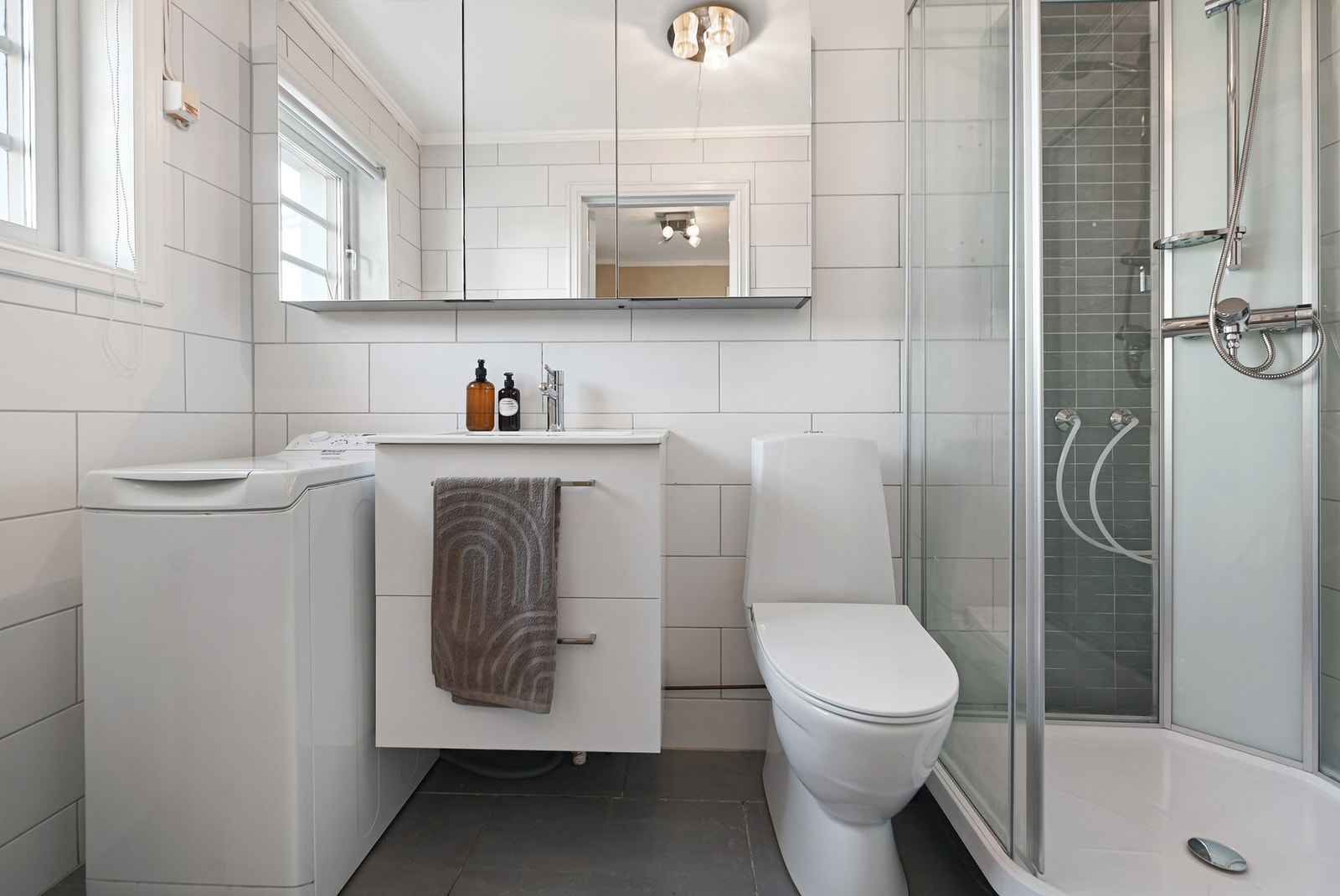 Badet er innredet med nedfelt servant, gulvfestet toalett, dusjkabinett (fra september 2025) og opplegg for vaskemaskin Galleribilde