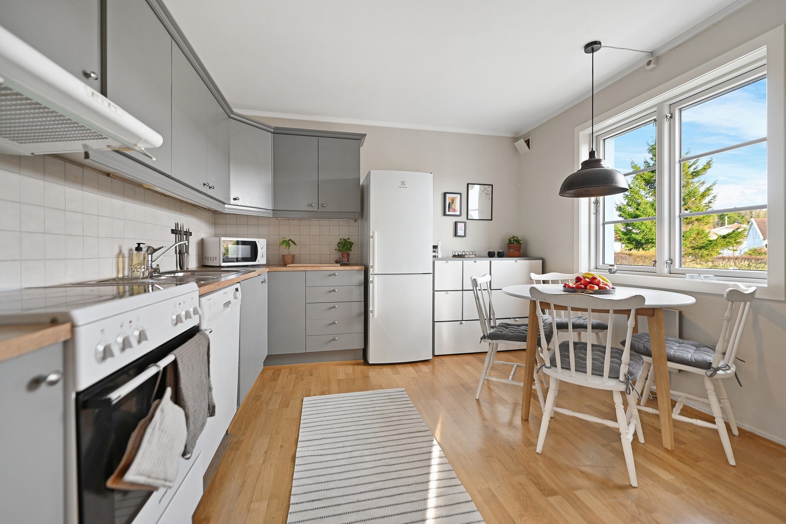 Kjøkkenet har slette fronter og laminat benkeplate. Frittstående komfyr og kjøl/fryseskap, underbygget oppvaskmaskin. Galleribilde