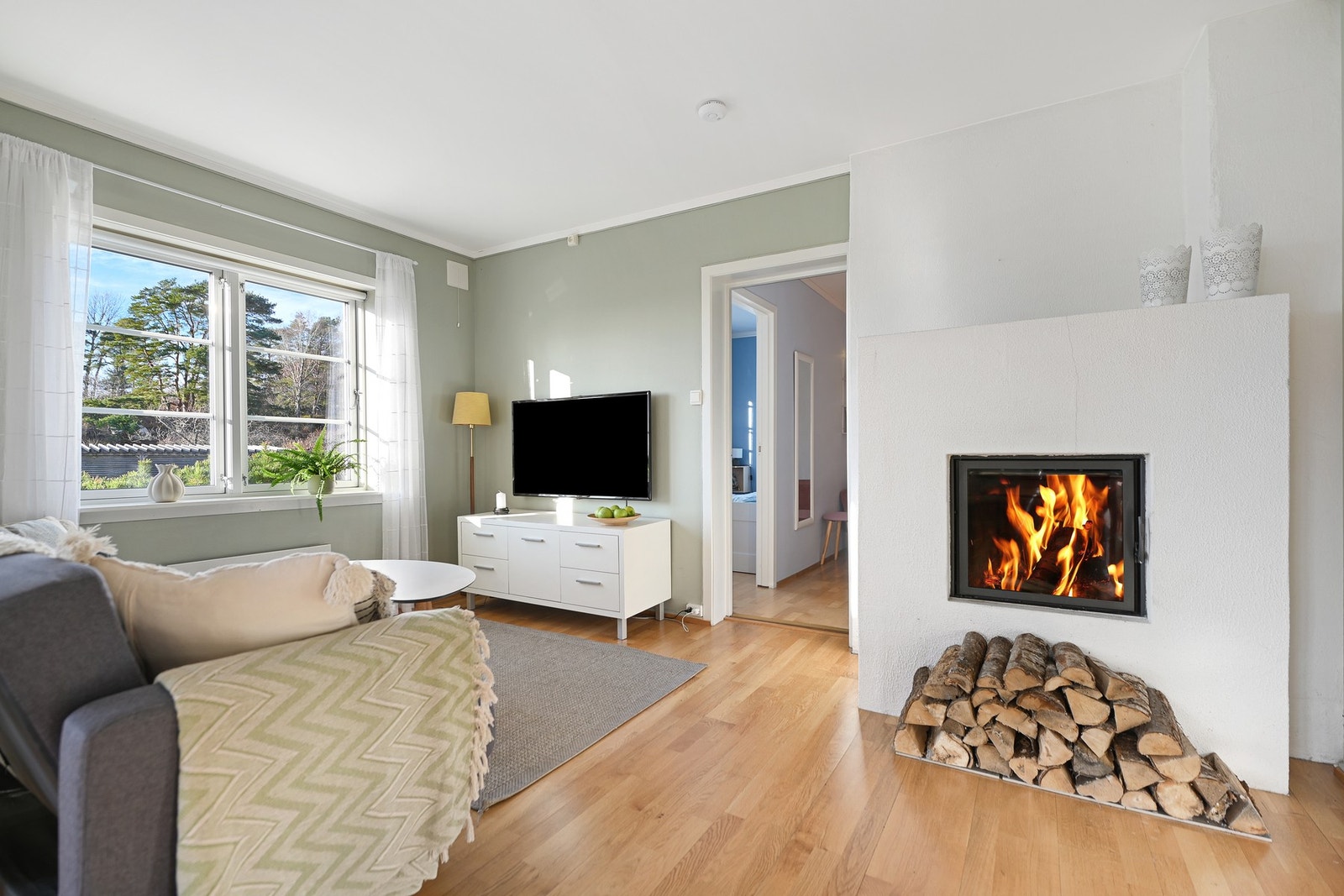 Sentralt i rommet er det peisinnsats som varmer godt og gir mye kos og hygge på mørke høst- og vinterkvelder. Galleribilde