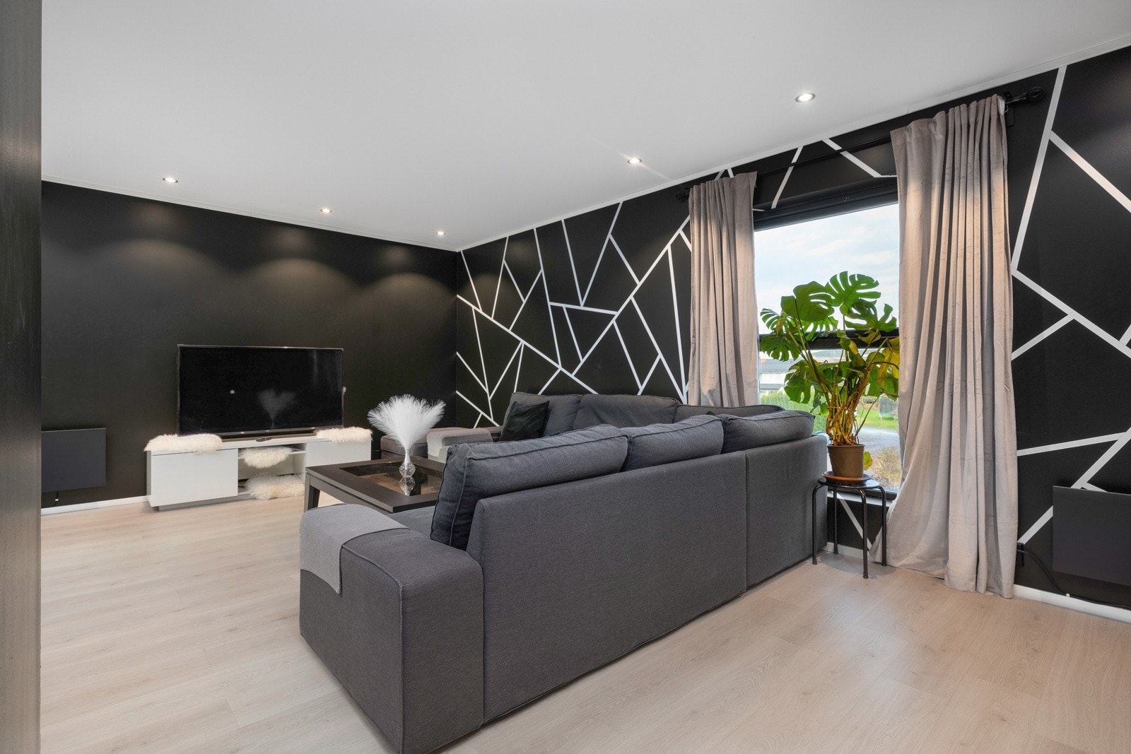 Romslig stue med lekre kontraster og store vinduer. Galleribilde