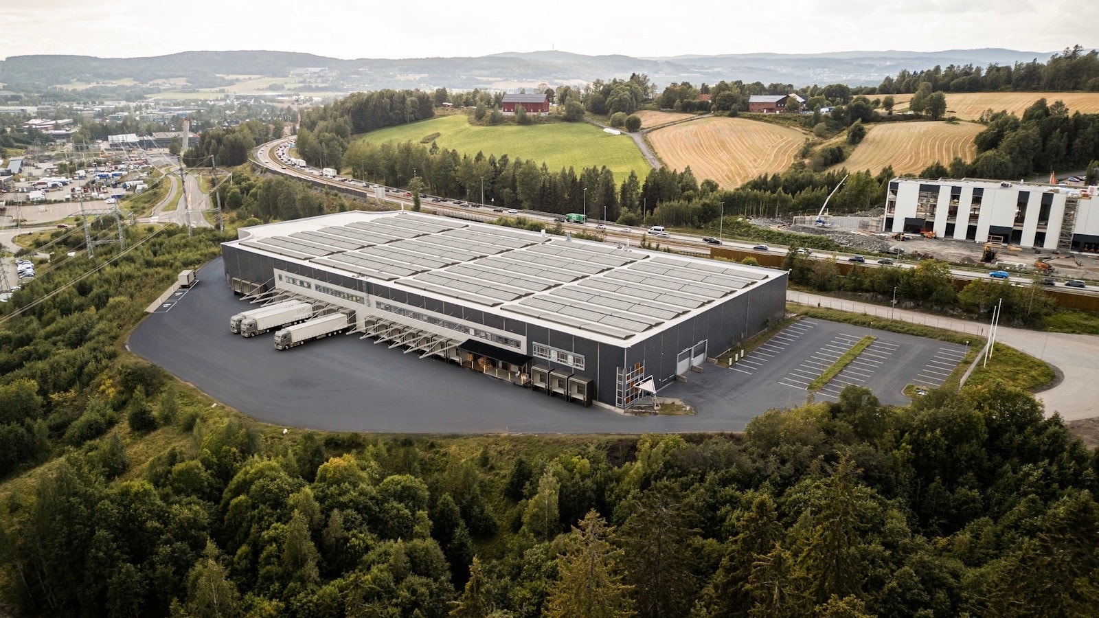 Bilde er redigert og viser tenkt oppgradering av tak med solcellepanel, flere kjøreporter med ladepunkter og ny asfalt Galleribilde