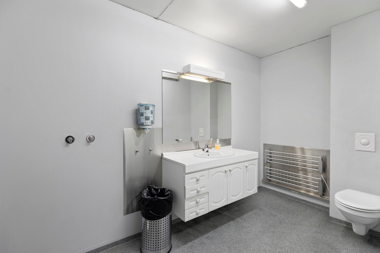 Bad med baderomsinnredning og vegghengt toalett Galleribilde