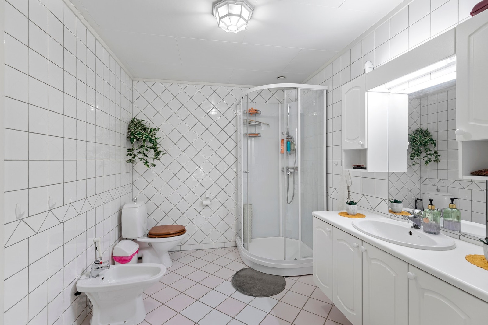 Helfliset bad med gulvvarme, dusjkabinett, baderomsinnredning, toalett og bidè Galleribilde