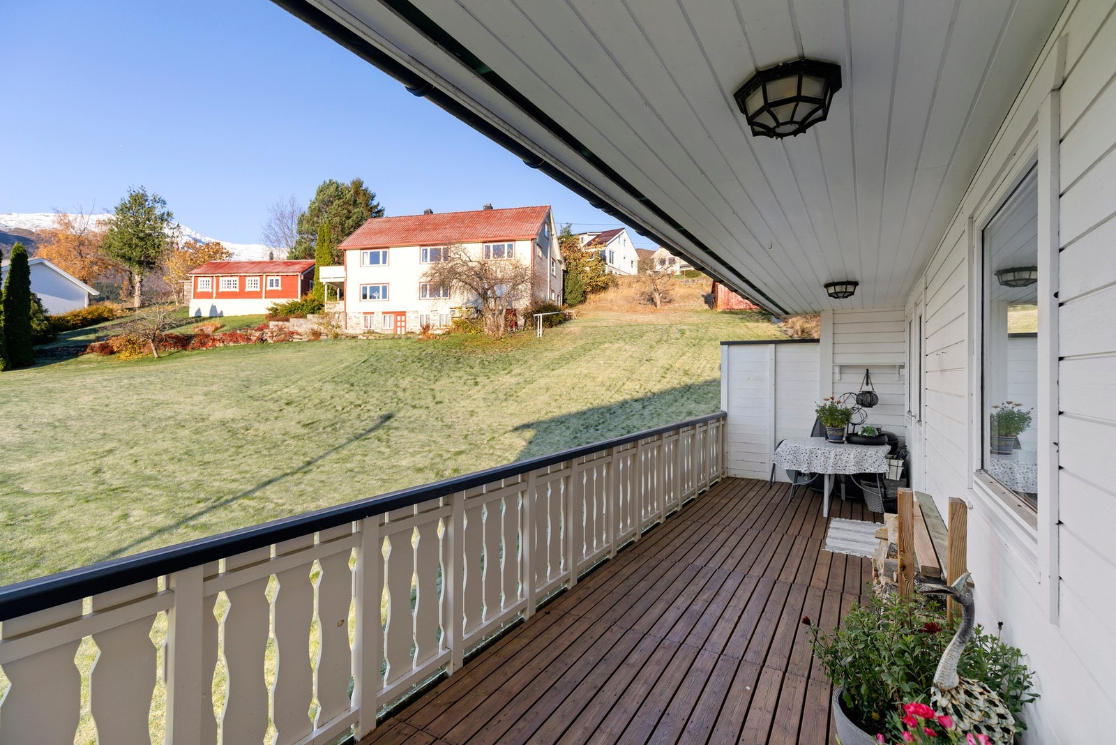 og utgang til en vestvendt veranda med flott kveldssol, og utsikt mot den omkransende fjellheimen Galleribilde