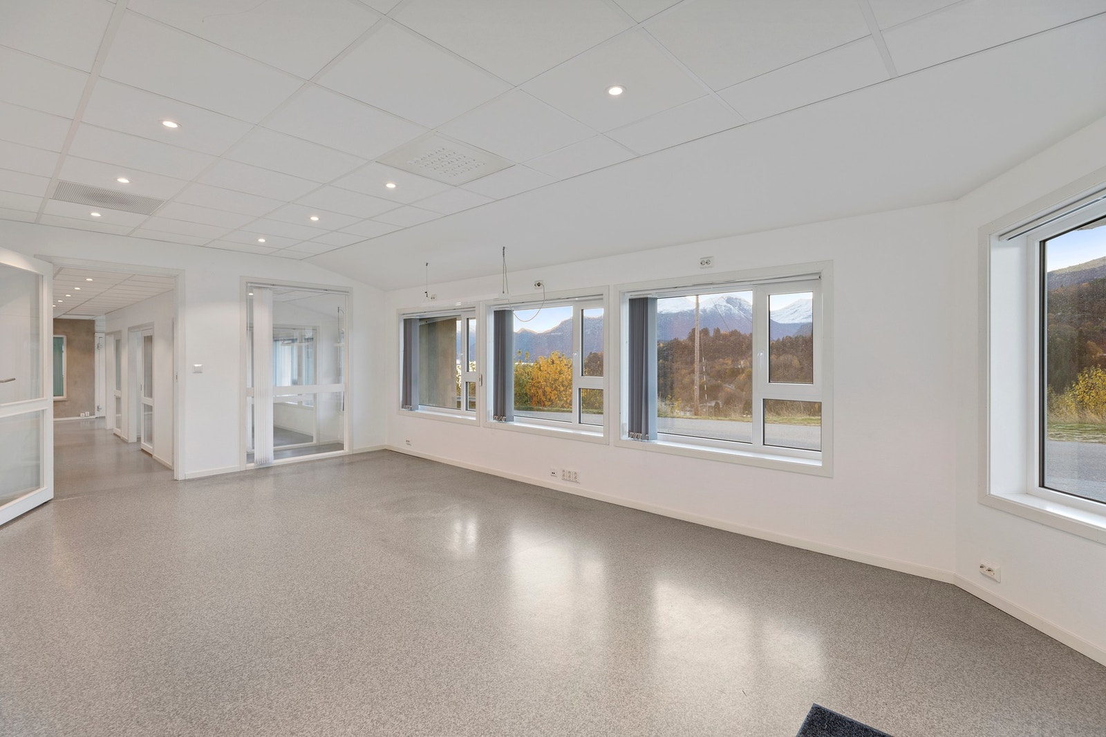 Rommene har mange, store vindusfelt som gir mye naturlig lys og god atmosføre i rommene. Dør videre til gang/bi-inngang og kontorer Galleribilde