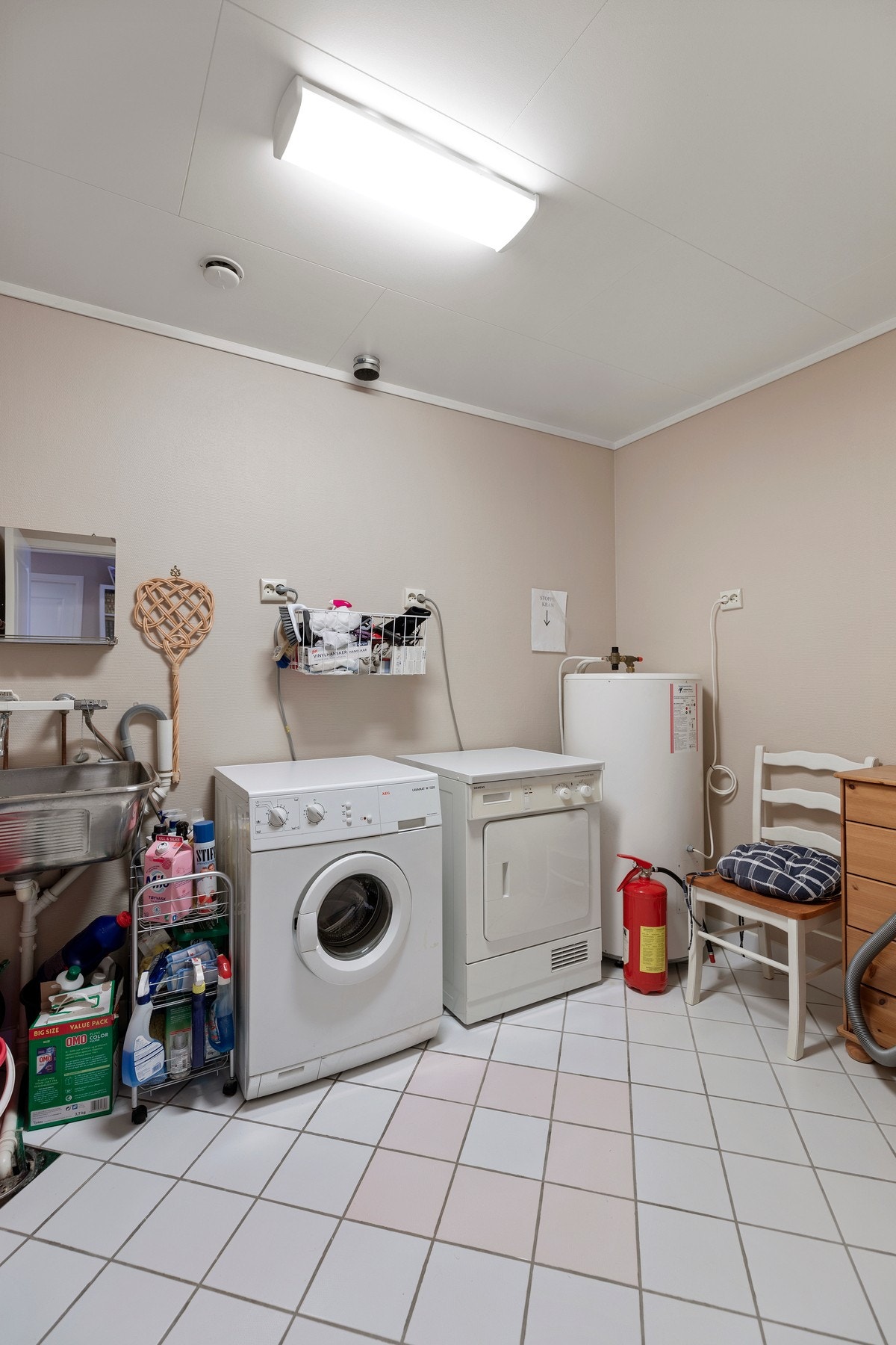 Vaskerom med flislagt gulvoverflate, skyllekum, vvbereder og opplegg for vaskemaskin Galleribilde