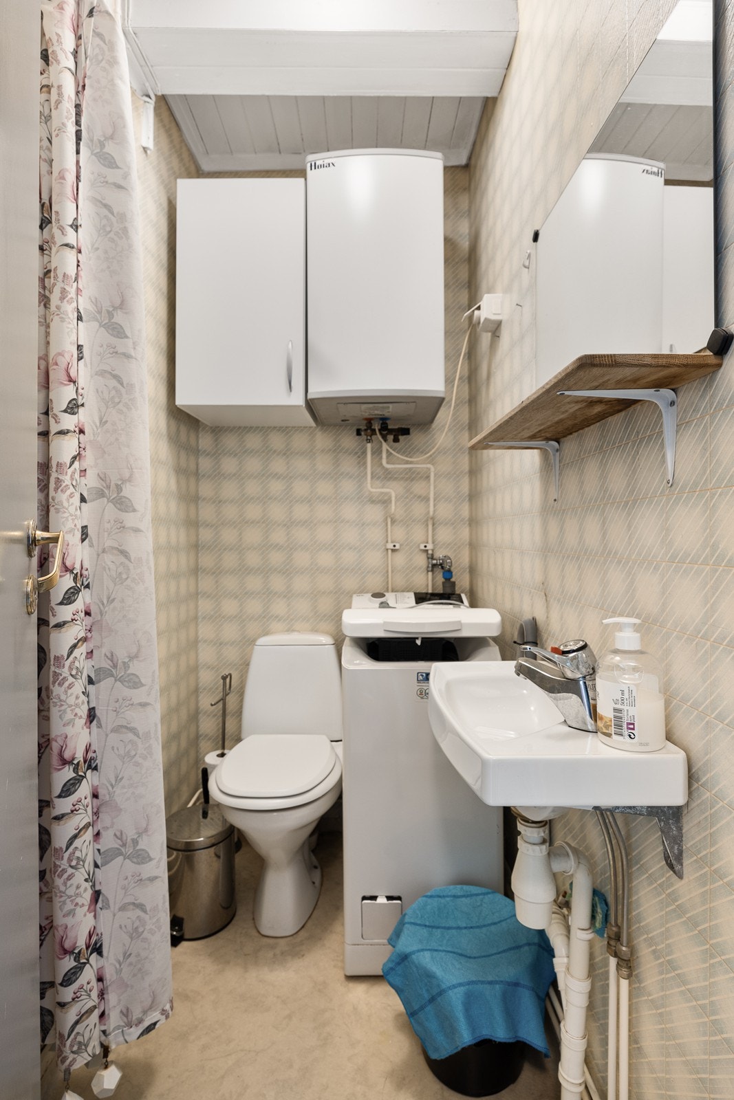 Toalettrom innredet med toalett, servant og opplegg for vaskemaskin. Galleribilde