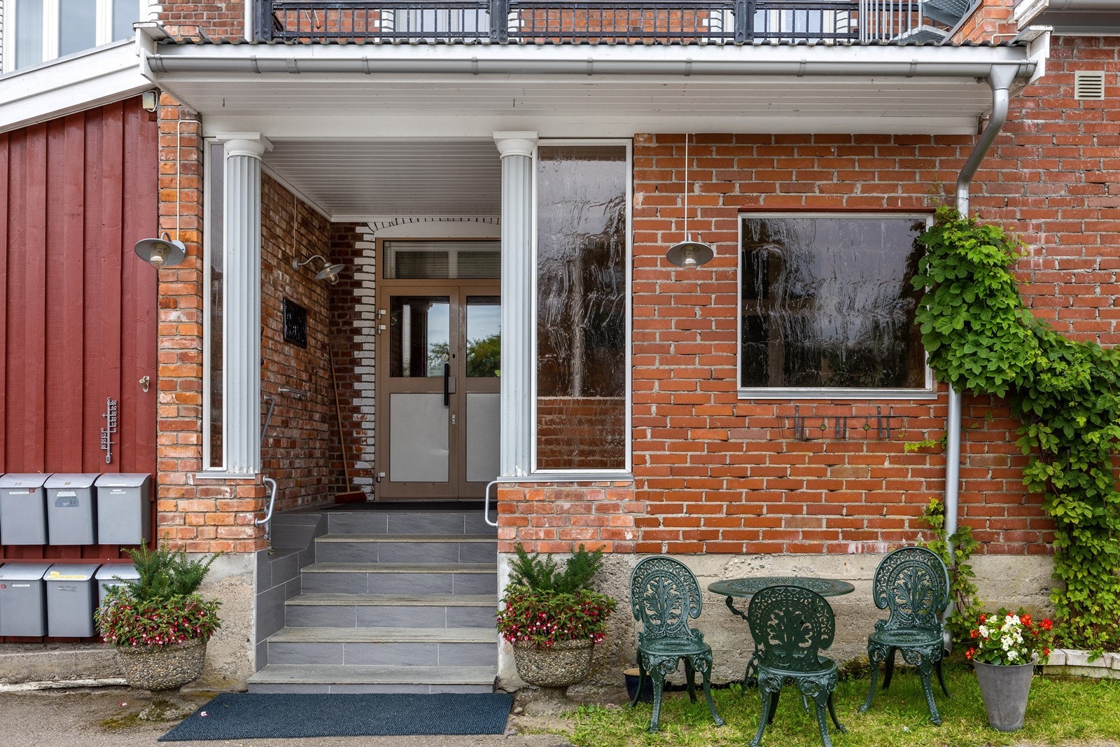 Trivelig inngangsparti på baksiden av bygget med søyler og trapp i sten. Galleribilde