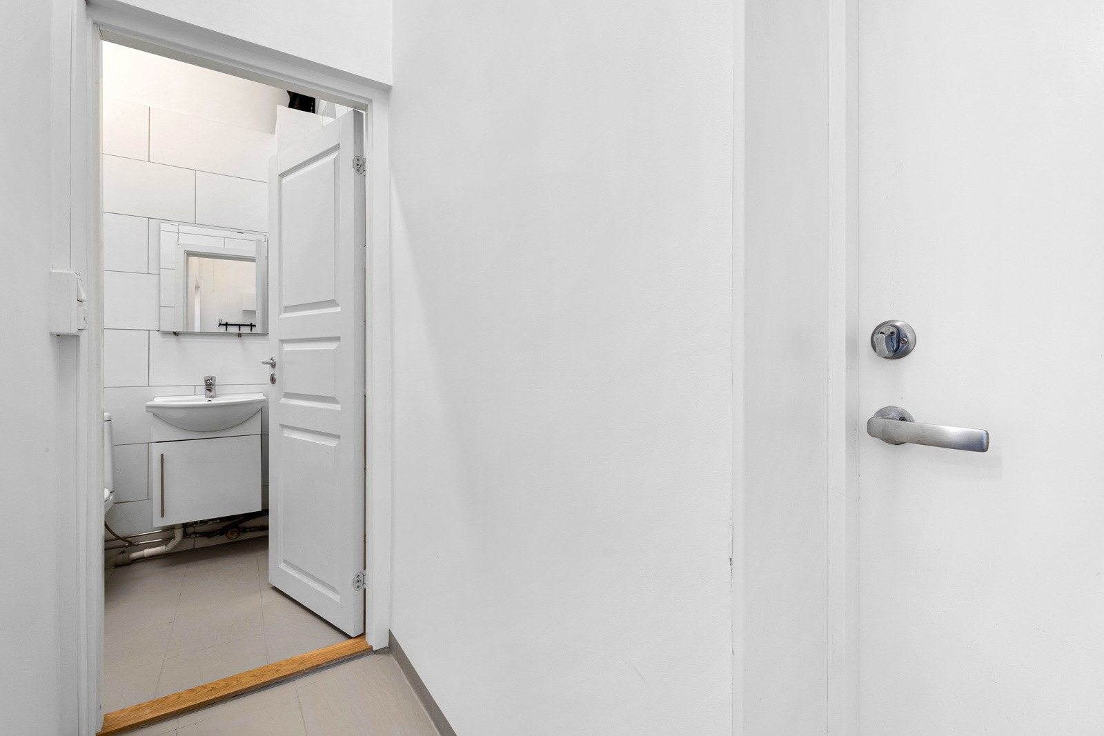 Lokalet har også et bad, med grå gulvfliser og hvite veggfliser. Galleribilde