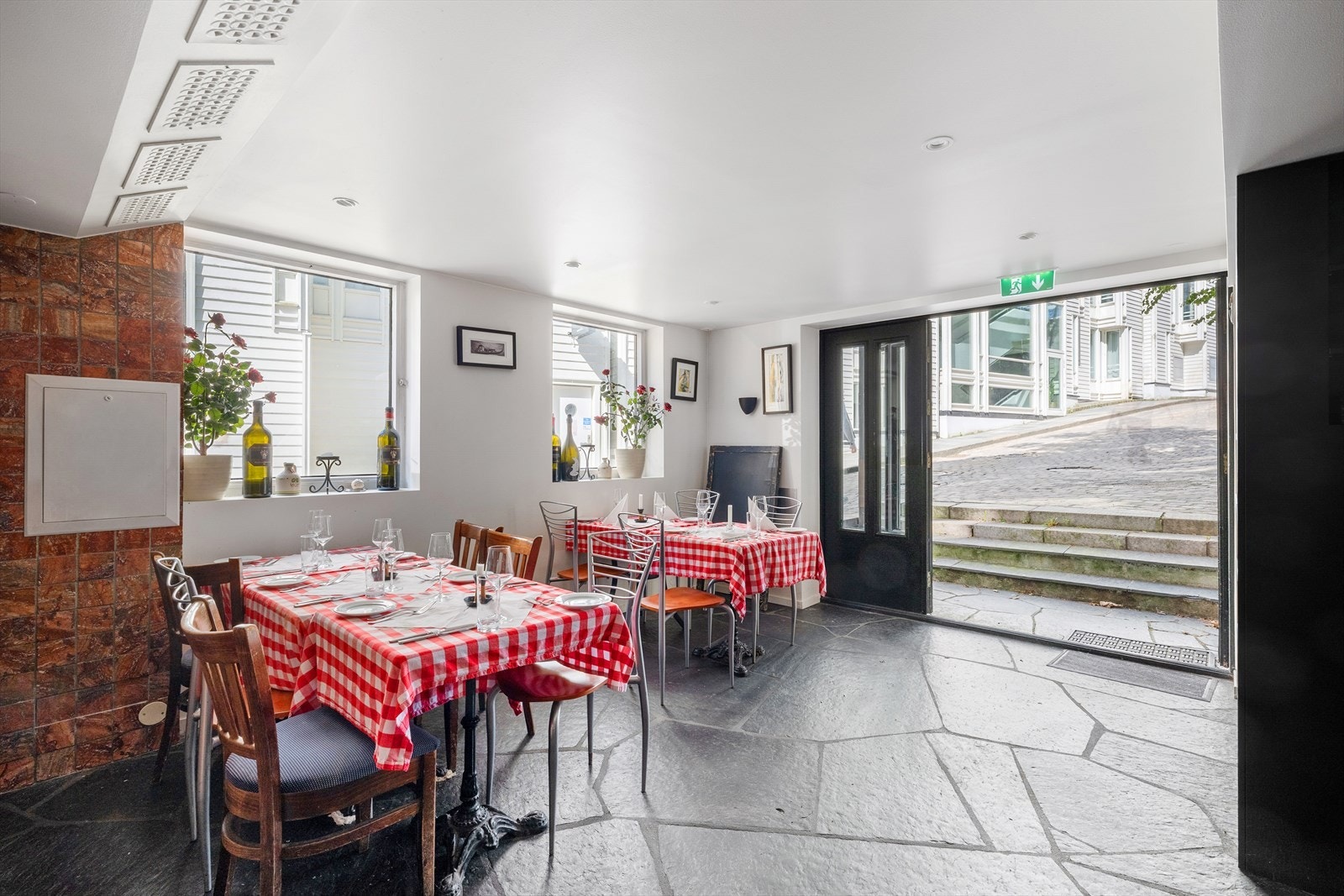 Restaurantlokale har lysmalte vegger og skifer på gulv. Galleribilde