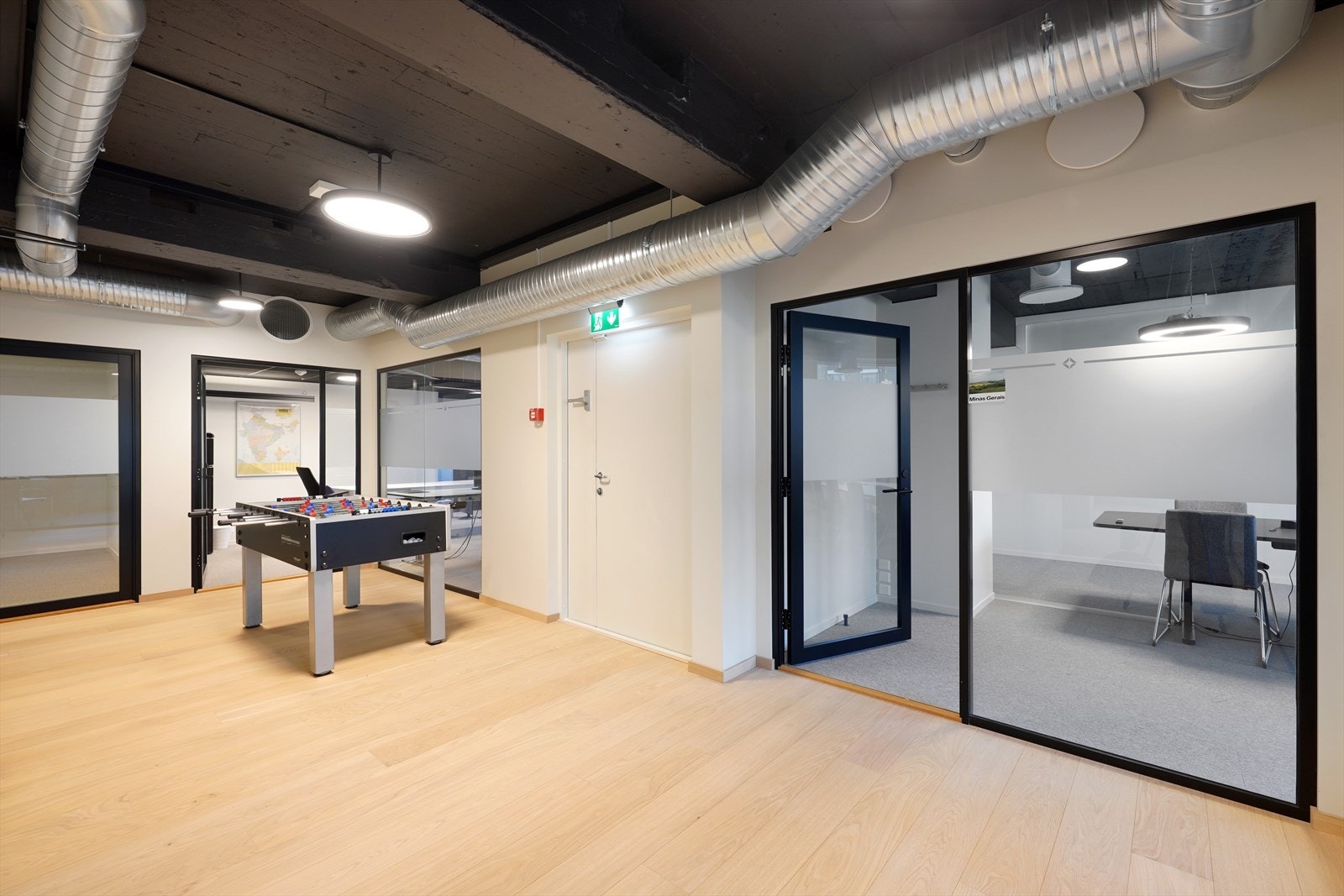 Moderne kontorlokale med glassvegger og parkettgulv. Lys og innbydende atmosfære, perfekt for kreative arbeidsmiljøer. Galleribilde