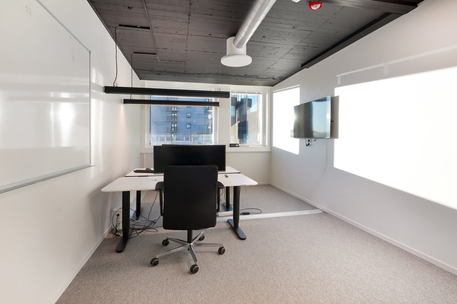 Lyst kontor med store vinduer som slipper inn rikelig med naturlig lys, perfekt for produktive arbeidsdager. Galleribilde