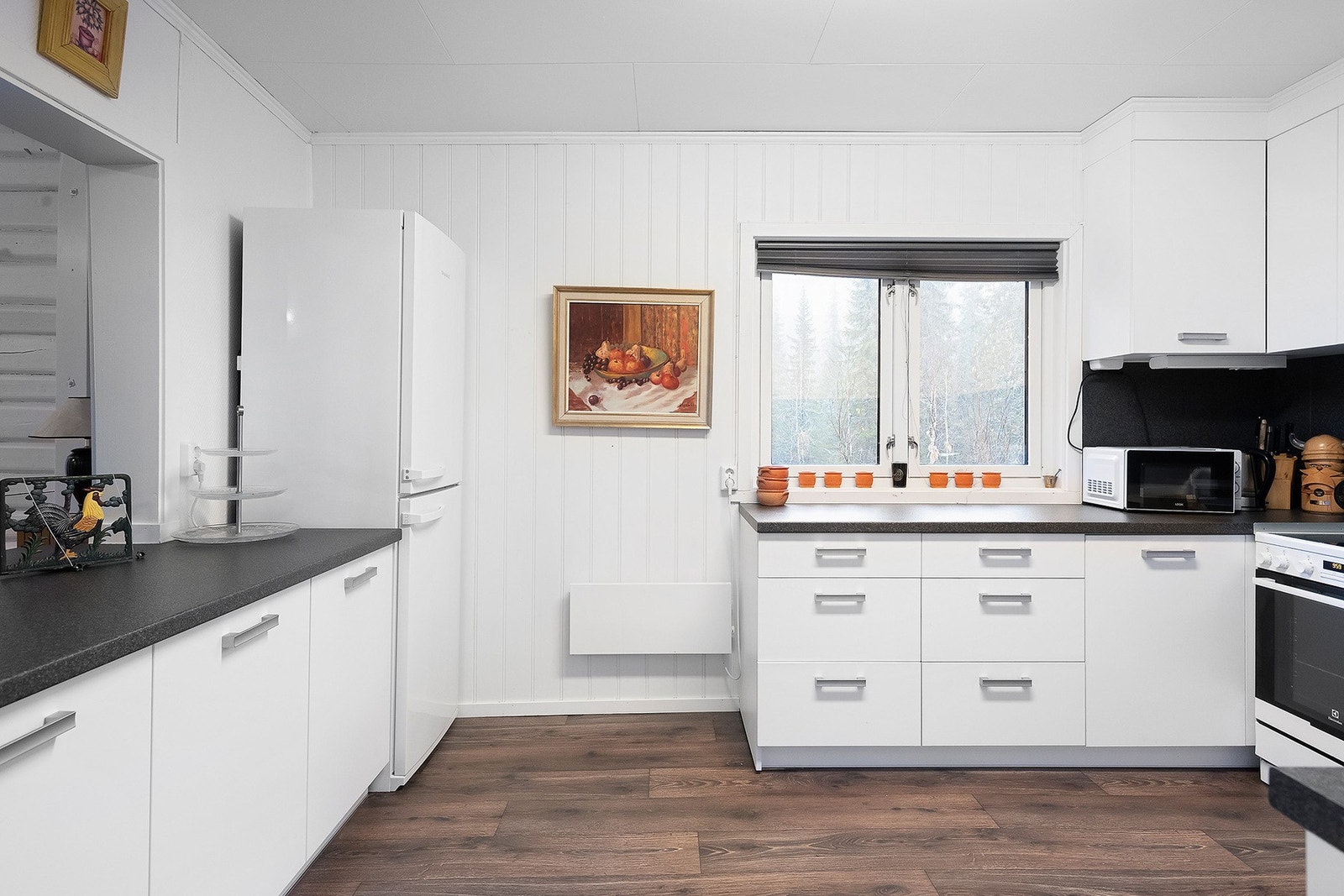 Kjøkkenet er av god størrelse og har rikelig med skap og benkeplass Galleribilde