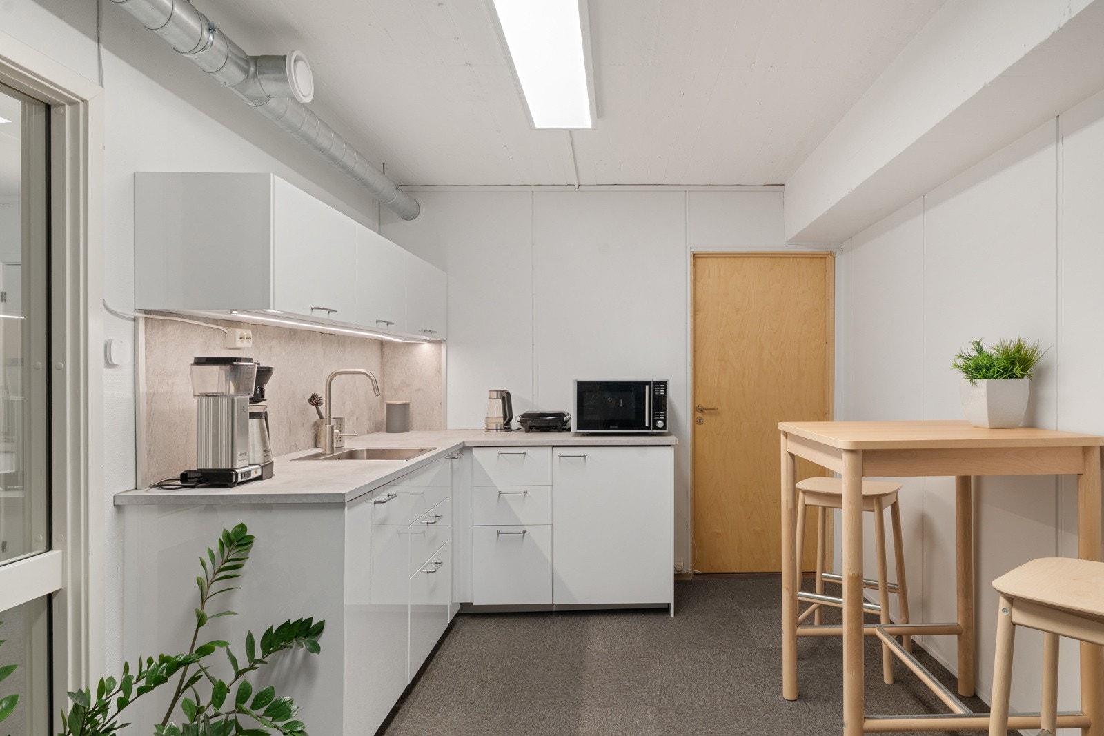 Kjøkkenet har glatte, hvite fronter og fremstår i god bruksmessig stand. Kjøkkenet er utstyrt med integrert oppvaskmaskin. Galleribilde