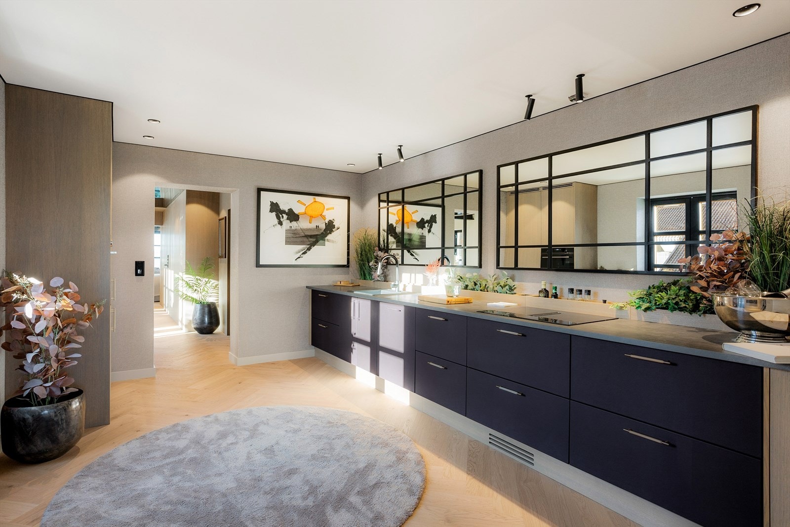 Med slette fronter i trukket skinn (2024), integrerte hvitevarer og eksklusive materialvalg, fremstår rommet både funksjonelt og luksuriøst. Galleribilde