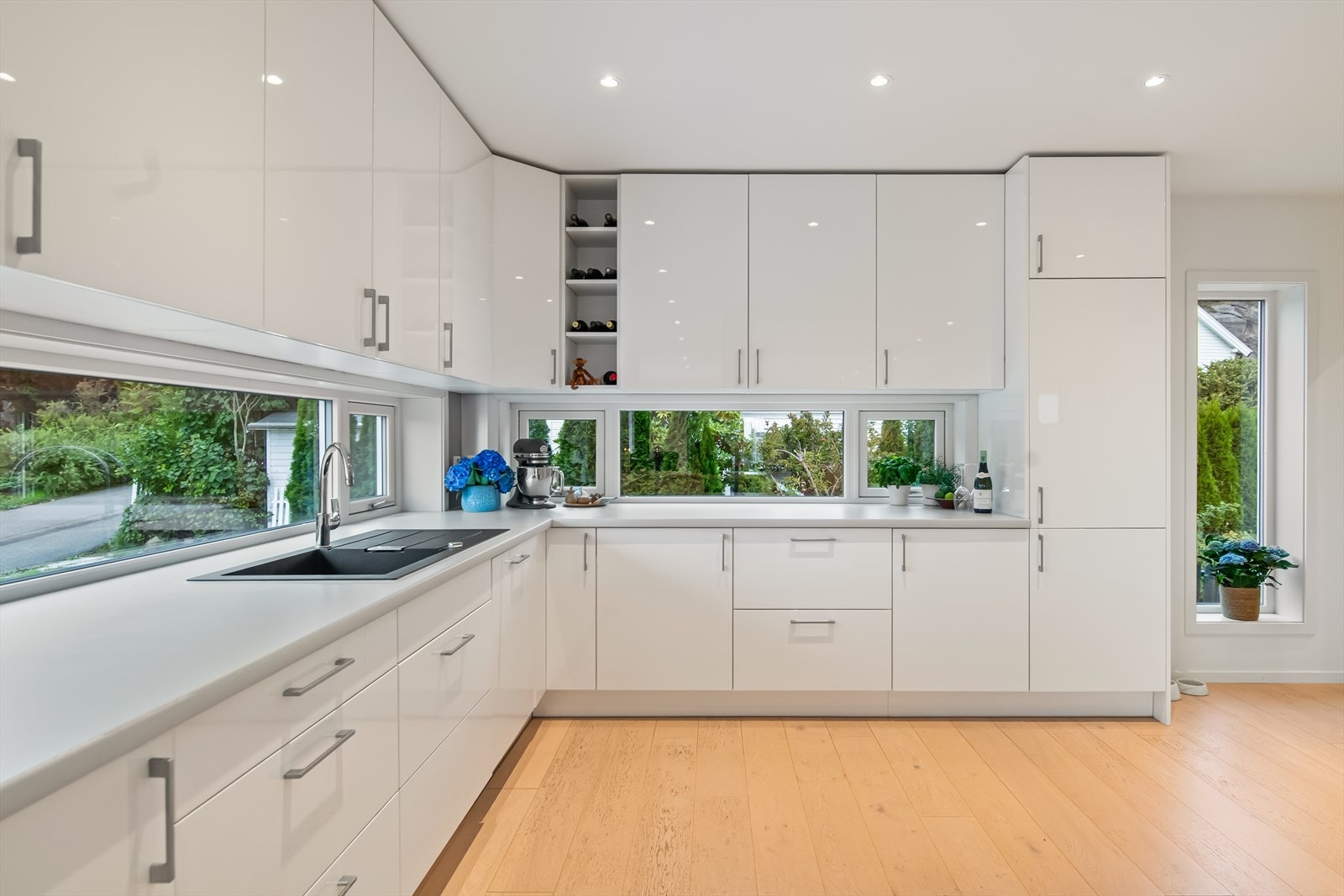 Kjøkkenet ligger i en fin og åpen løsning til stuen. Innredningen har rikelig med både benke- og skapplass og slette fronter i høyglans. Galleribilde