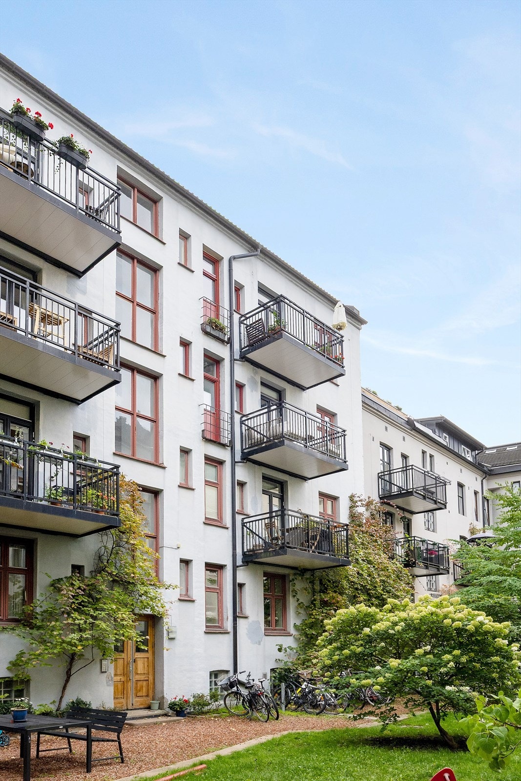 Bakgård har rikelig med grønn beplanting som skaper en herlig atmosfære for beboerne. Galleribilde