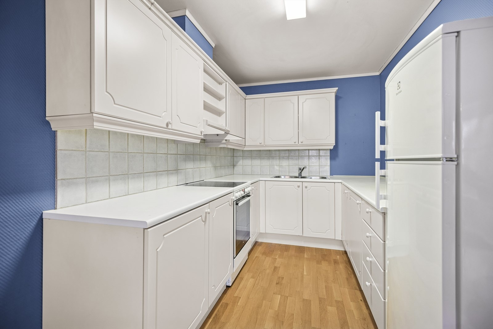 Det er fliser over benken i våtsonen, utslagsvask med blandebatteri, samt belysning under overskapene. Galleribilde