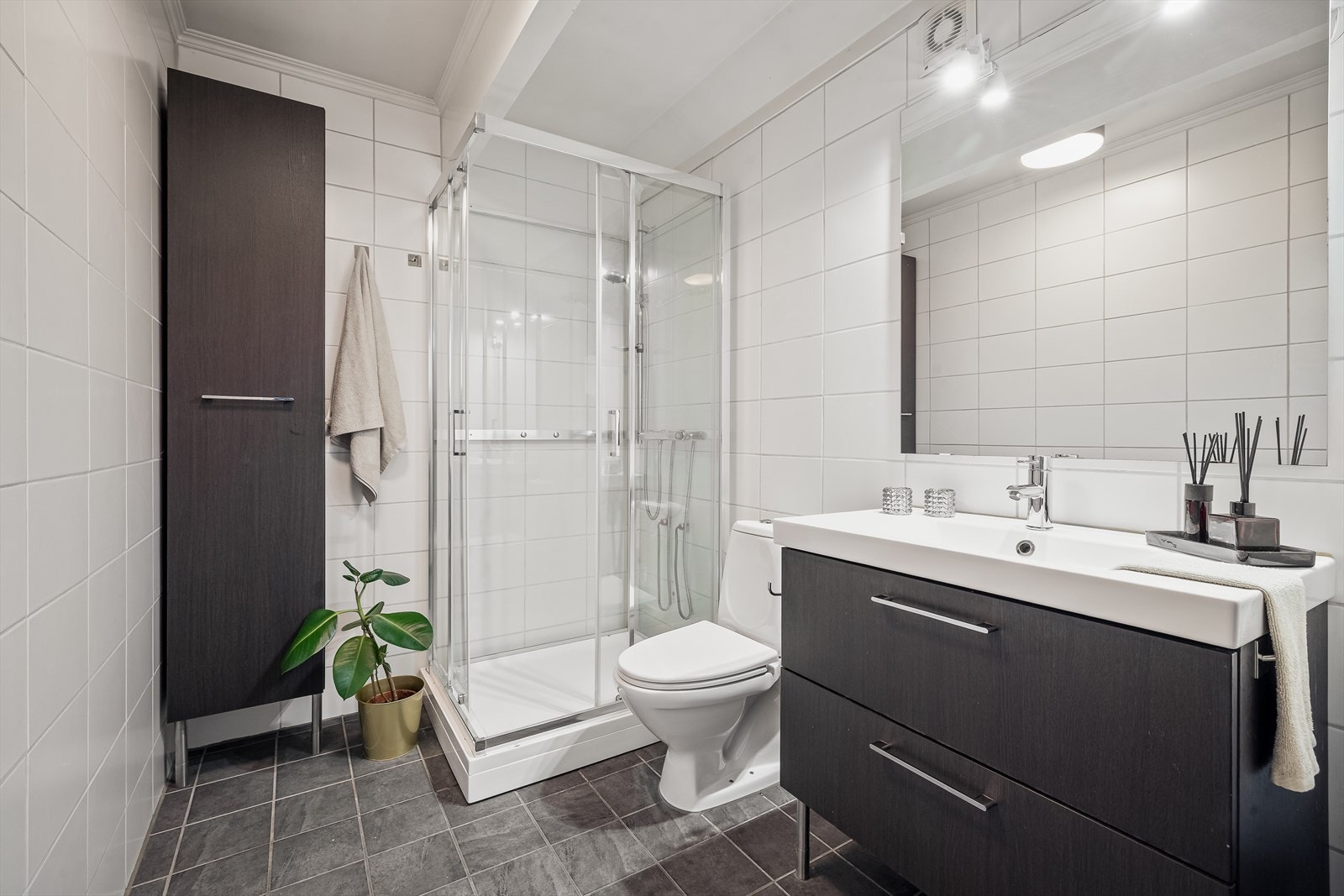 Det er flislagt med varmekabler i gulvet og inneholder toalett, innredning med servant og dusjkabinett. Galleribilde