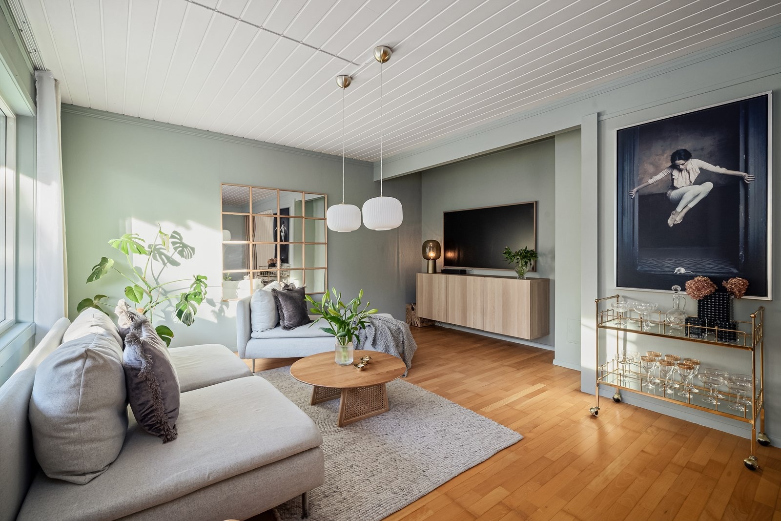 Stuen har veggoverflater malt i en dus og behagelig fargetone mot et solid parkettgulv og lysmalt himling. Galleribilde