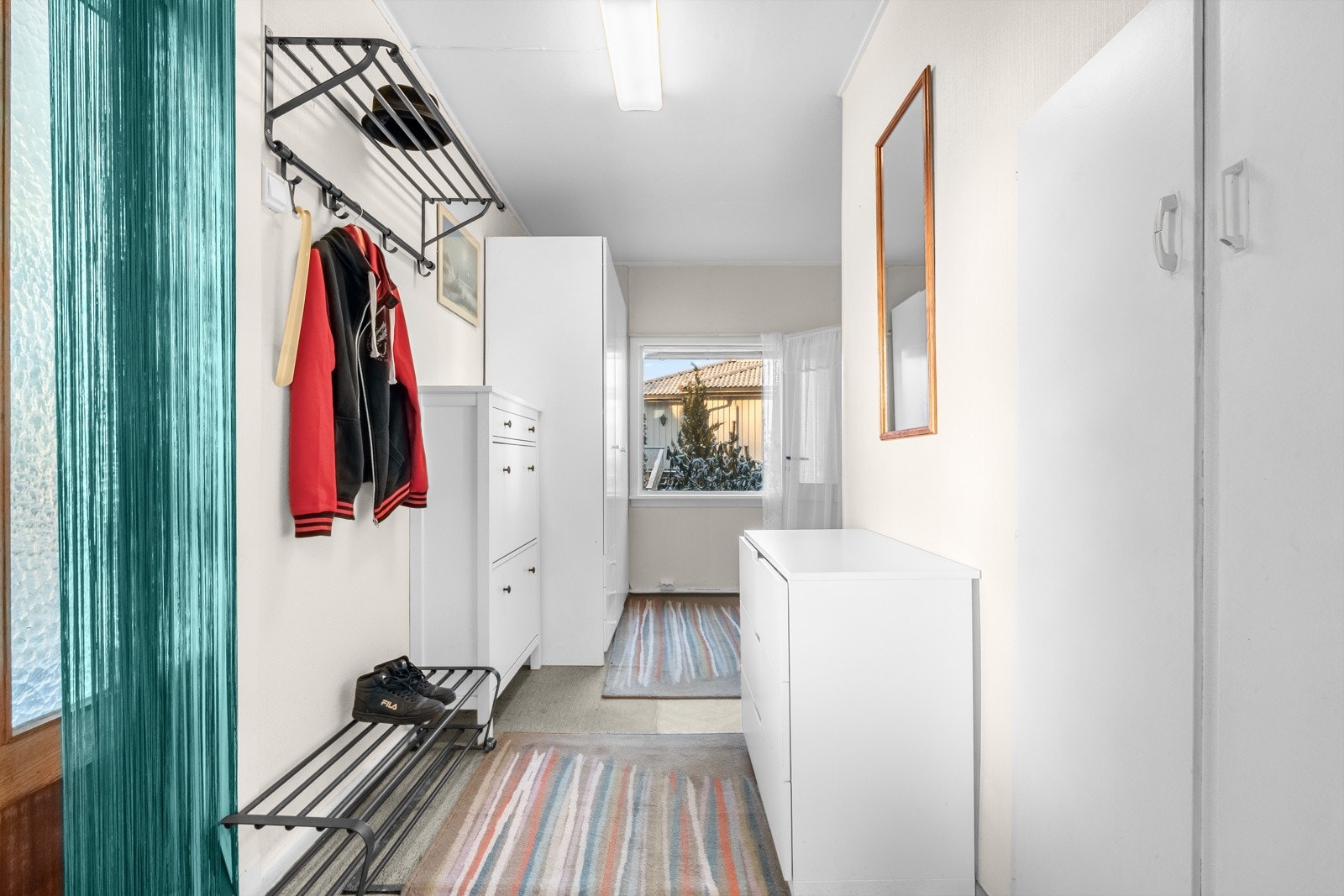 Når du entrer boligen kommer du inn i en lys og praktisk entré med belegg på gulv og lysmalte overflater. Galleribilde