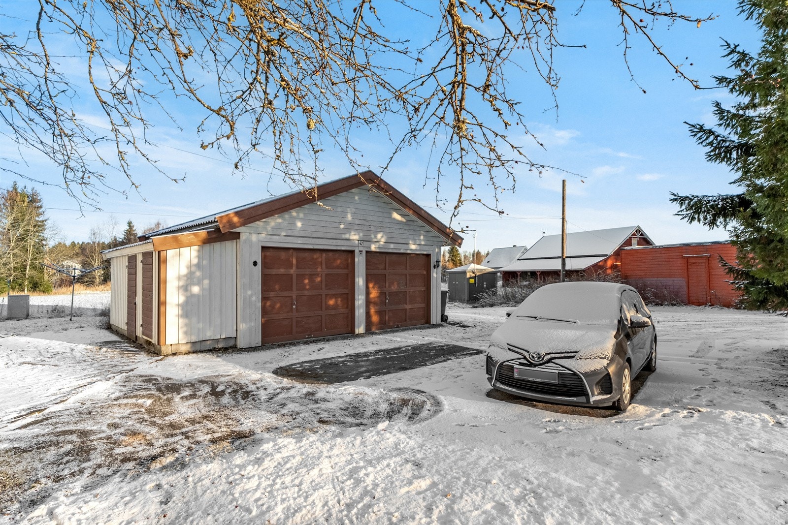 Eiendommen er også bebygd med en dobbeltgarasje på 34m² med 2 inntilbygde boder på 3m². Galleribilde