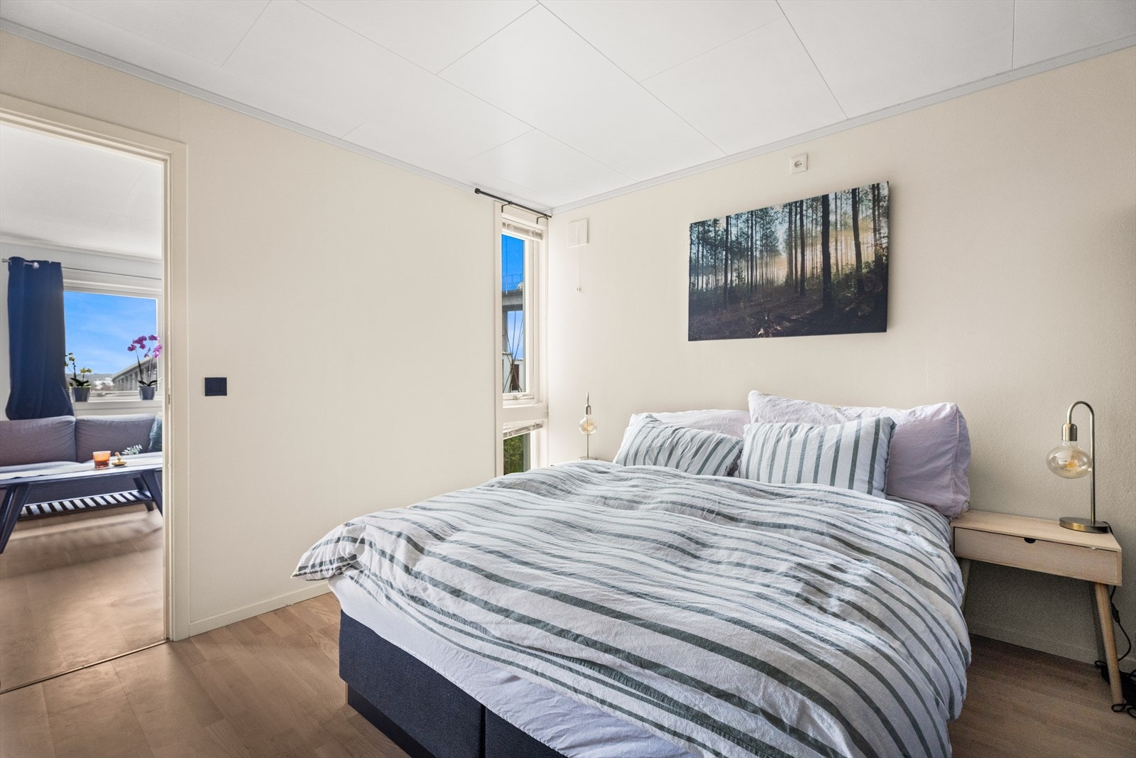 Soverommet har god plass til dobbeltseng og nattbord, og fremstår lunt med parkettgulv og lyse fargetoner på veggene Galleribilde