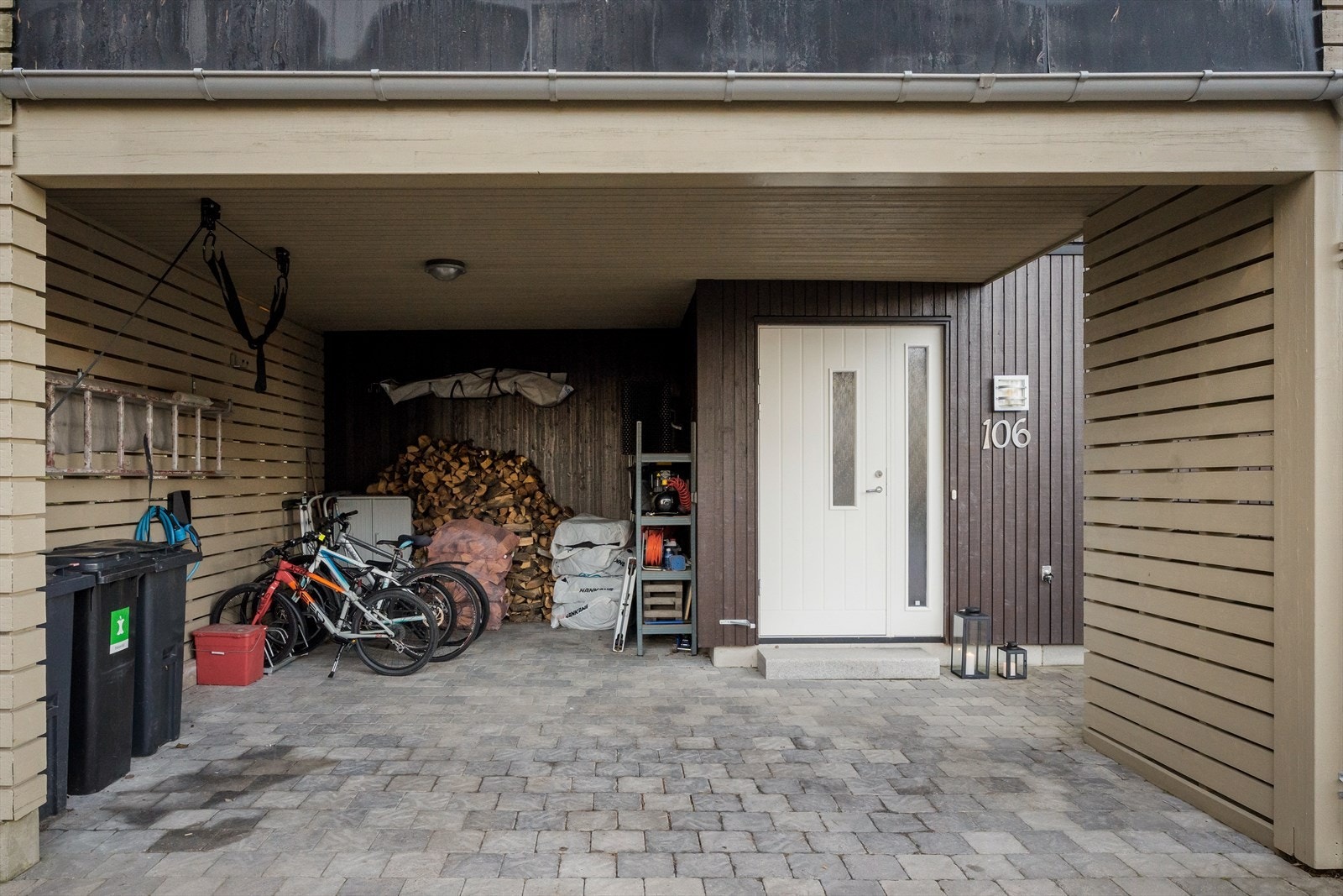 Carport med steinlagt gårdsplass gir beskyttet parkering. Galleribilde