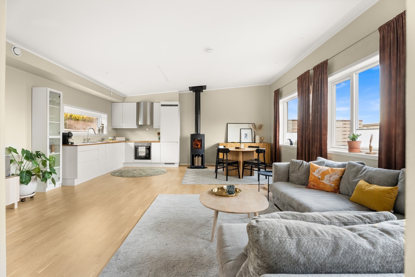 Kjøkken med lyse slette fronter og heltre benkeplate. Kjøkkenet har integrerte hvitevarer, inkludert oppvaskmaskin og komfyr. Galleribilde