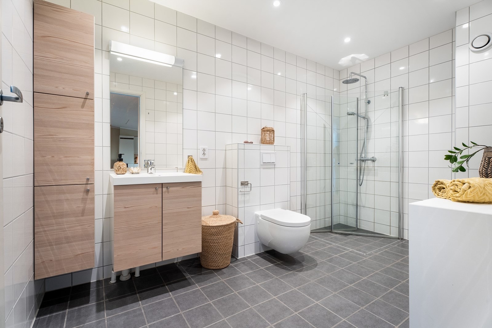 Pent og romslig baderom med flislagte vegger og gulv samt elektriske varmekabler. Galleribilde