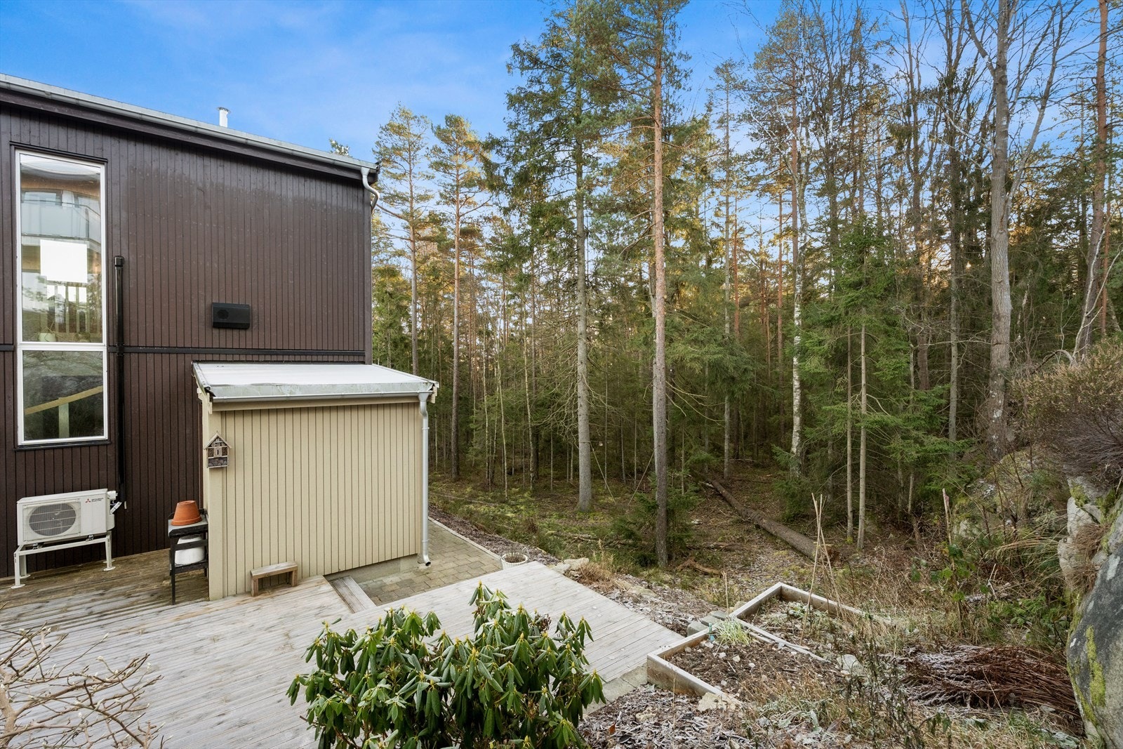 Romslig uteplass med utsikt mot skogområde. Galleribilde