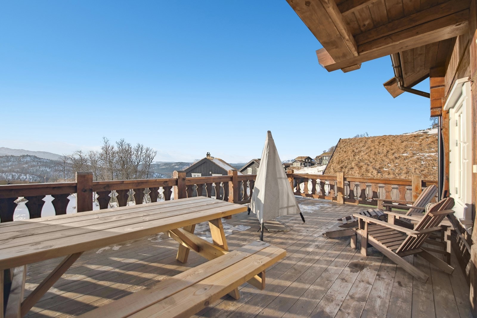 Solrik veranda med panoramautsikt. Verandaen er solrik hele året og byr på en fantastisk utsikt over fjell og vidder. Her kan du nyte solen samtidig som du følger med på aktivitetene i alpinbakken. Galleribilde