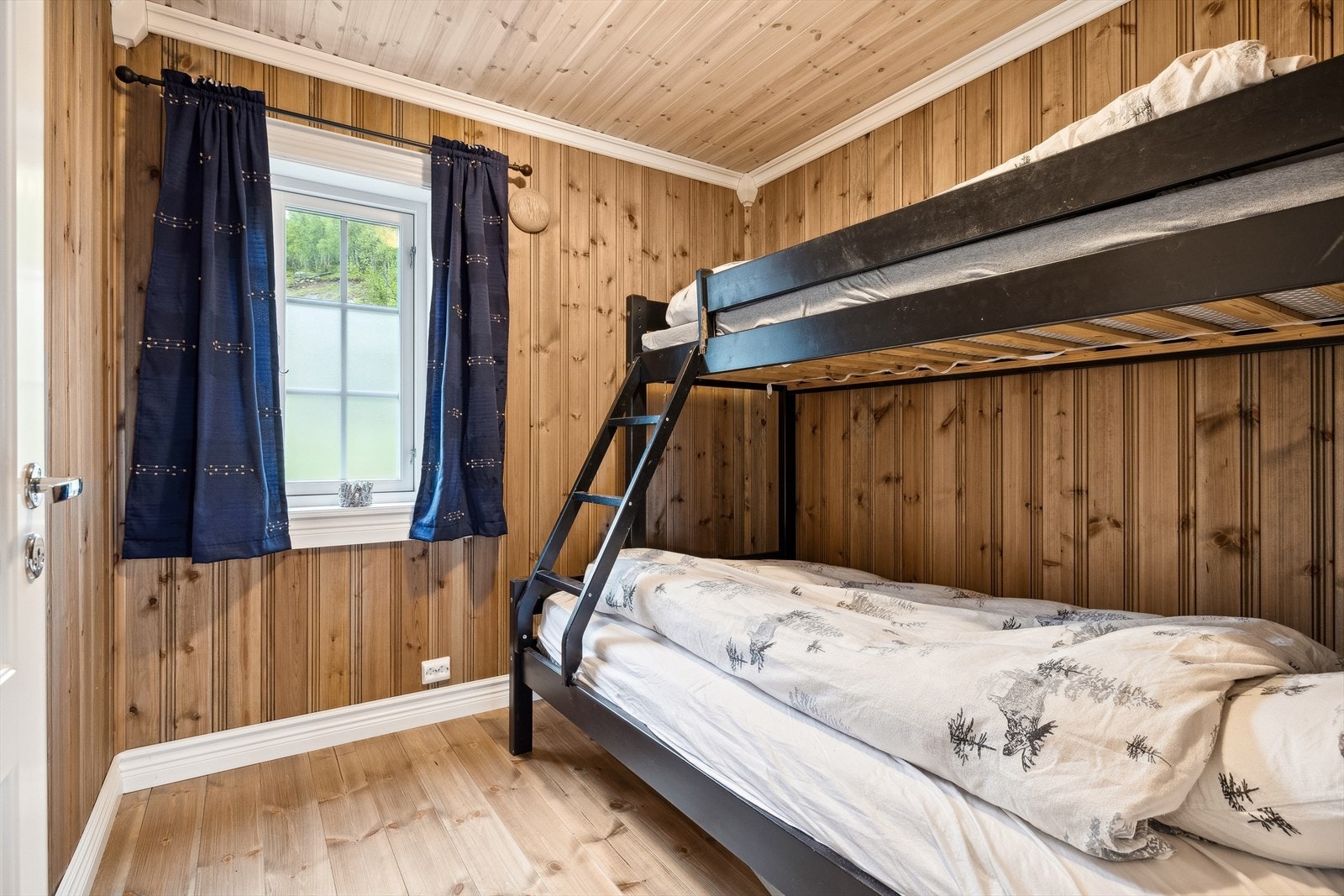 Fritidsboligen har 1 soverom i 1. etg. og 3 soverom i 2. etg. Soverommene er av god størrelse, med god plass til seng og oppbevaringsmøblement. Her har vi soverommet i første etasje. Galleribilde