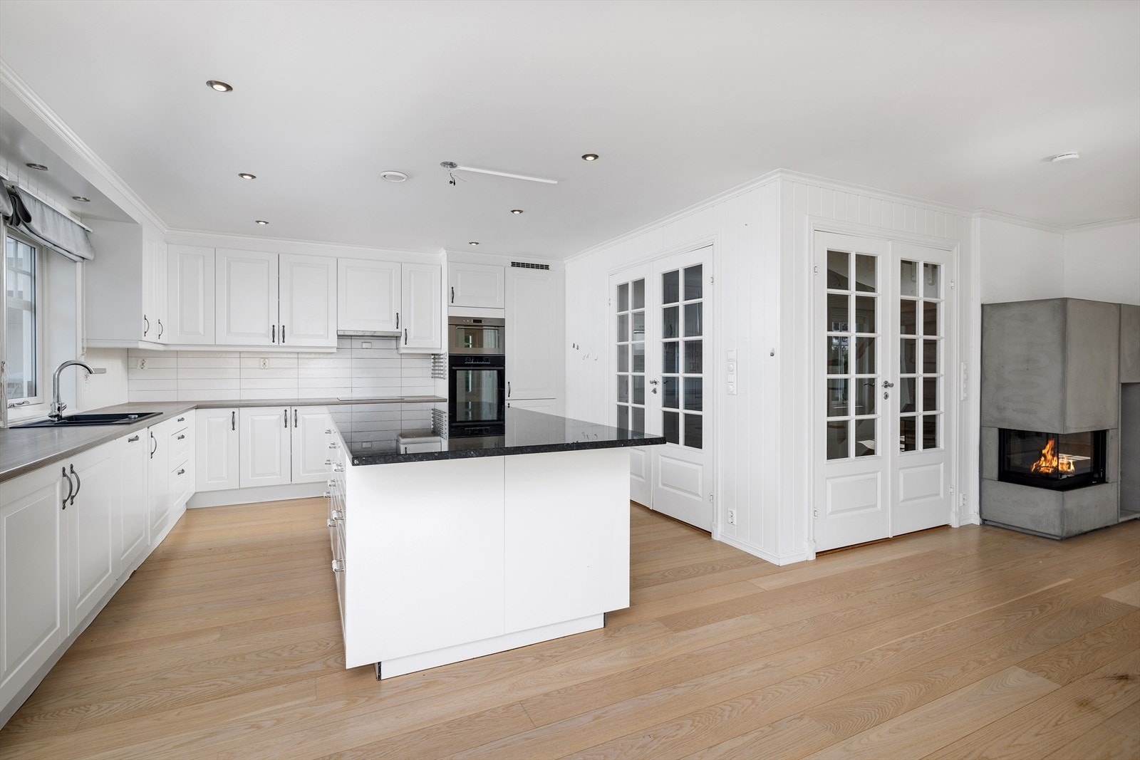 Elegant og tidløs kjøkkeninnredning fra byggeår med profilerte hvite fronter og benkeplate av laminat. Galleribilde