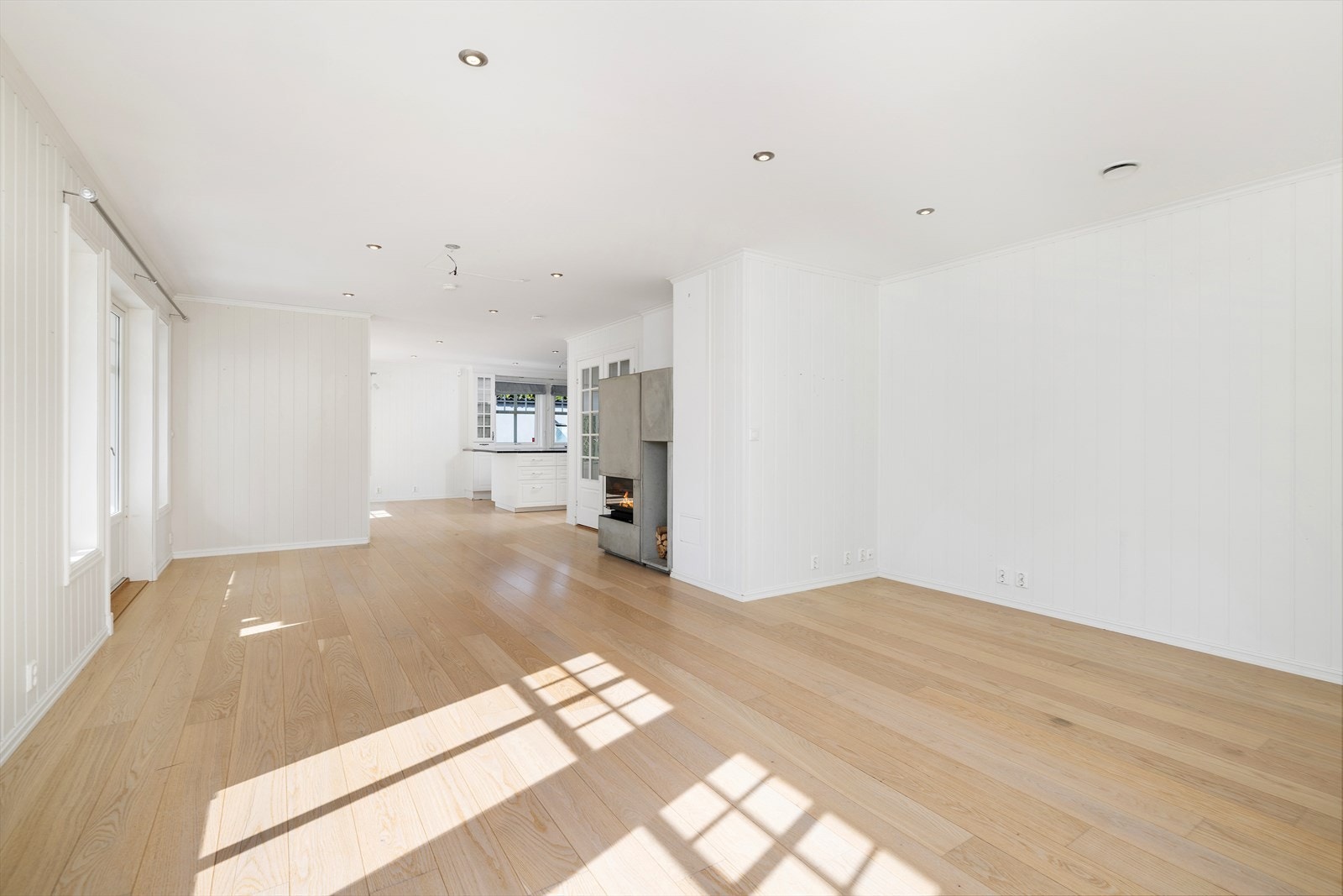 Stuen i 1.etasje er tidsriktig innredet og svært innbydende med 1-stavs parkett på gulv og hvitmalt panel på vegger malt. Galleribilde