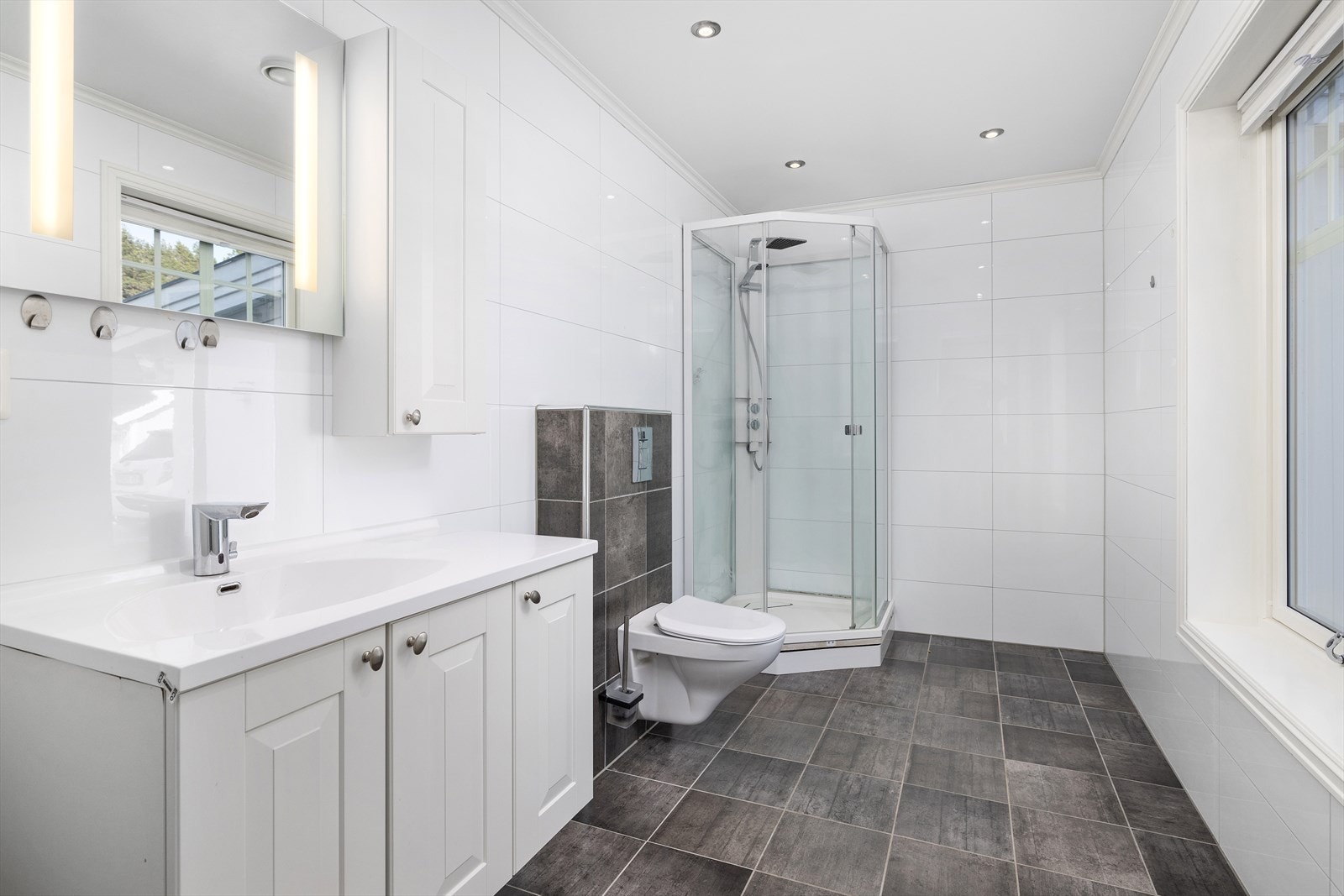 Delikat bad i 1.etasje. Badet har lyse fliser på vegg og mørkere på gulv med varmekabler. Galleribilde