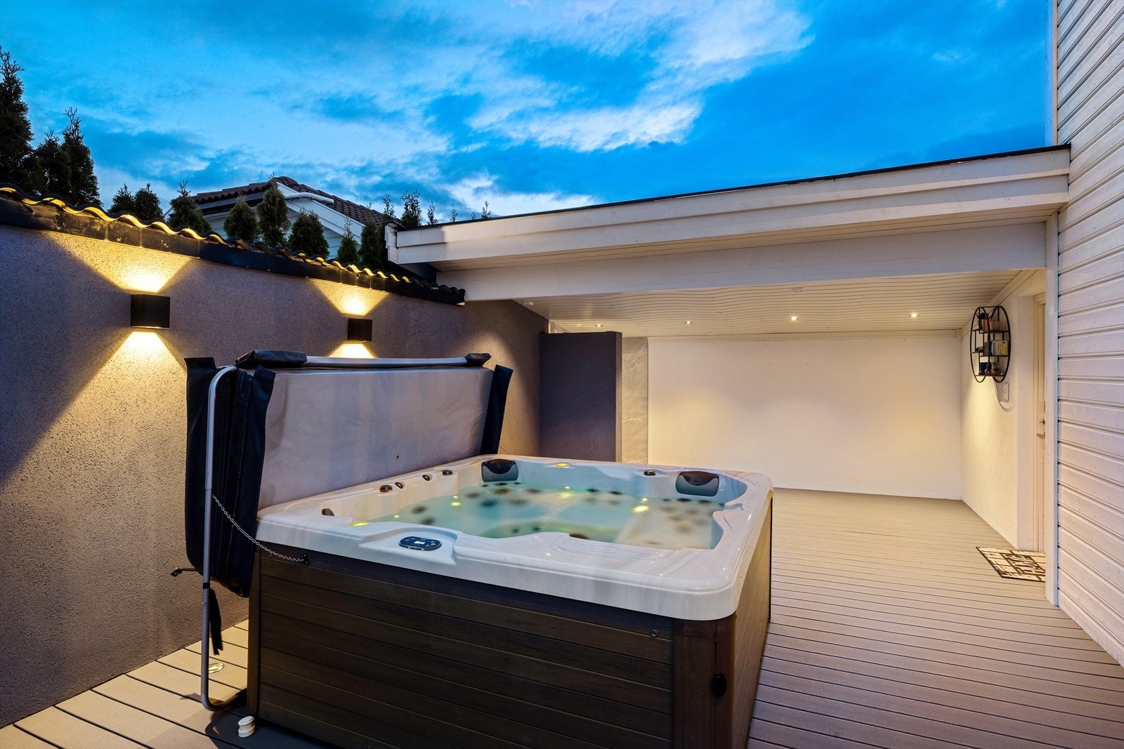 En jacuzzi tilfører en touch av luksus, mens det skiferlagte området gir et elegant og tidløst uttrykk. Galleribilde