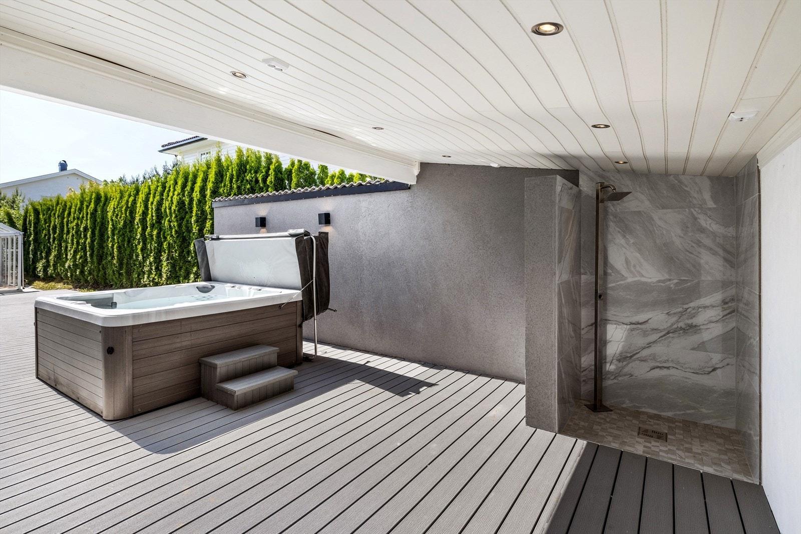 Det er bygget en overbygget uteplass med fin ute dusj. Galleribilde