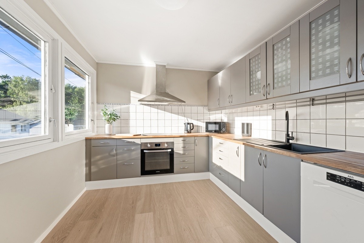 Vis-à-vis stua finner vi et stort og rikt kjøkken med store arbeidsflater og god plass til oppbevaring. Hvitevarer inkluderer oppvaskmaskin, komfyr, mikrobølgeovn, to kjøleskap og en fryser Galleribilde