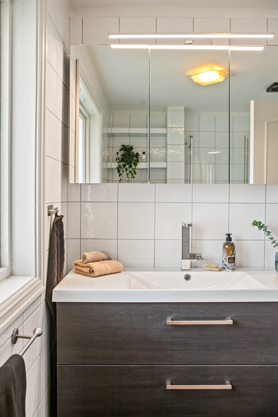 Videre har badet et vegghengt toalett, mekanisk avtrekk og et dusjhjørne med regnfallsdusj og innfellbare glassdører. Galleribilde