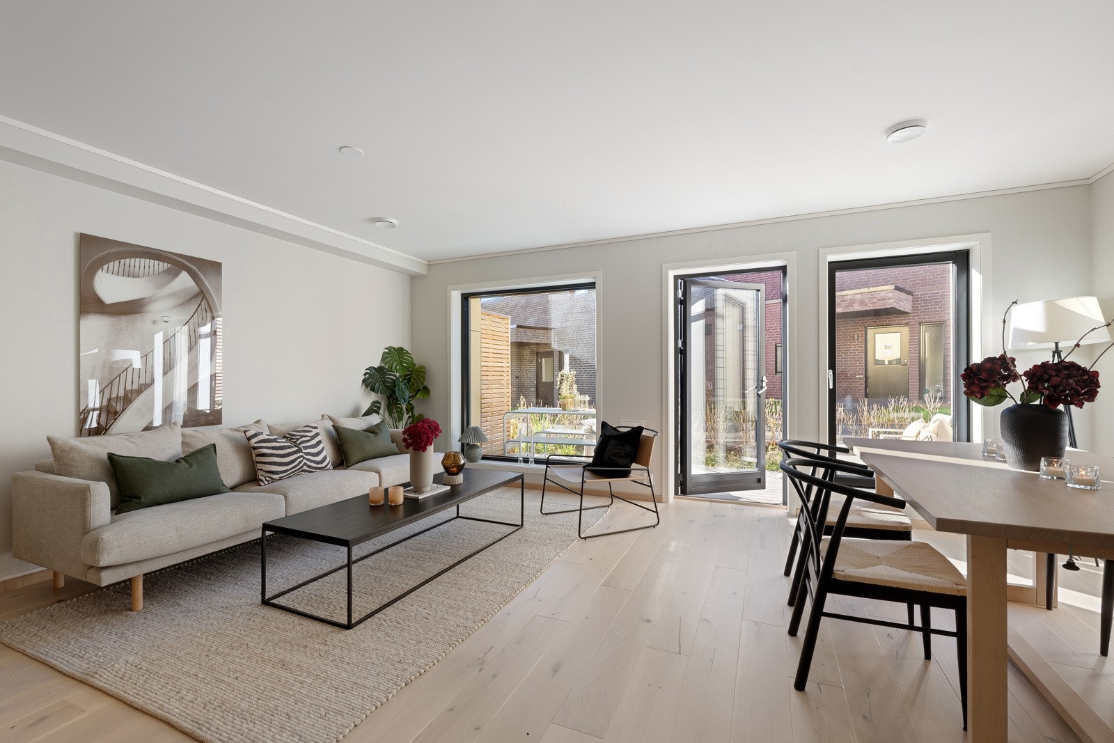 Lys og innbydende stue i 1. etasje med peisovn, store vindusflater og 1-stavs parkett på gulvet. Galleribilde