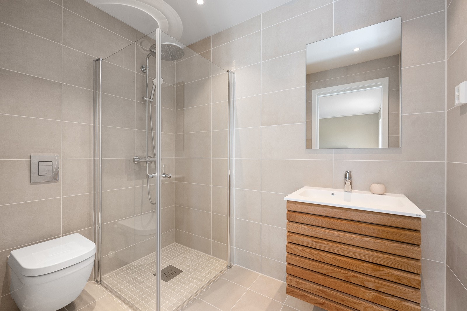 Eget bad i tilknytning til hovedsoverom med dusj, toalett og servant med underskap. Galleribilde