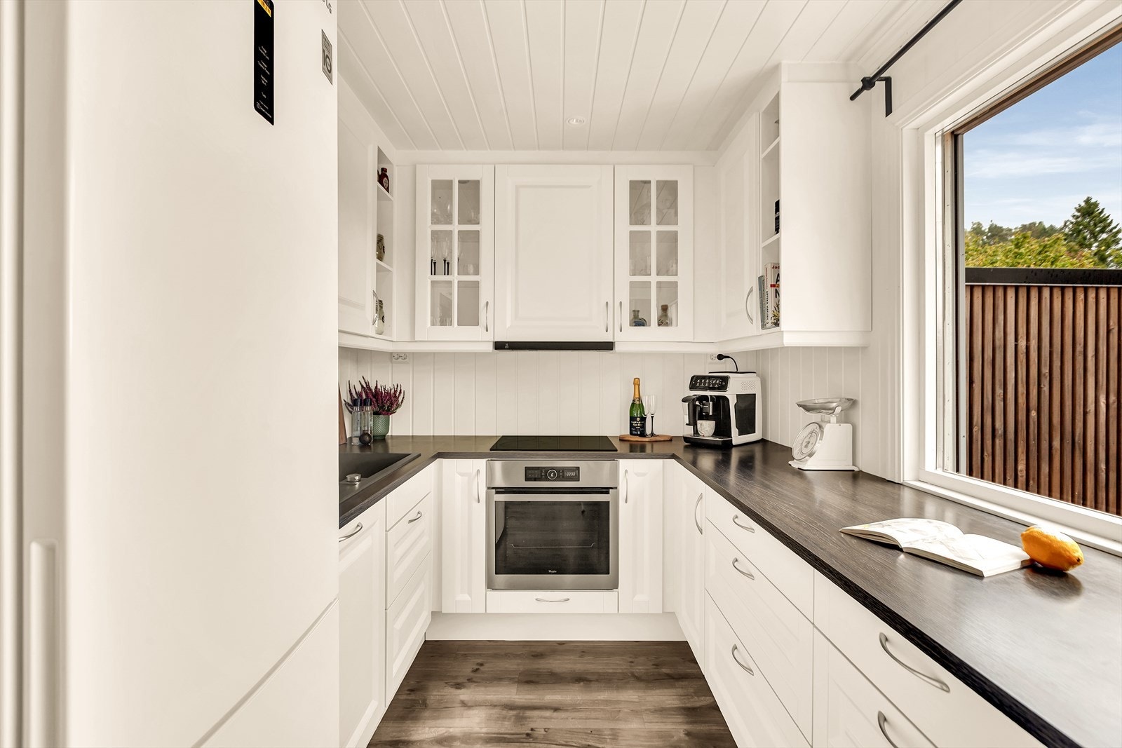 Innredningen har skap med profilerte fronter. Deler av overskapfronter har innfelt glass. Det er spotter innfelt i overskapet. Galleribilde