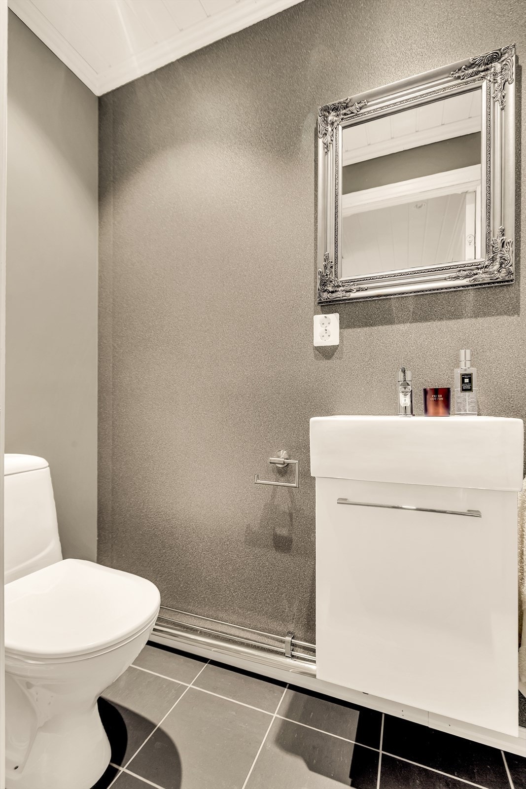 Fra entréen er det inngang til et toalettrom. Rommet er utstyrt med gulvstående toalett samt servant med underskap. Galleribilde